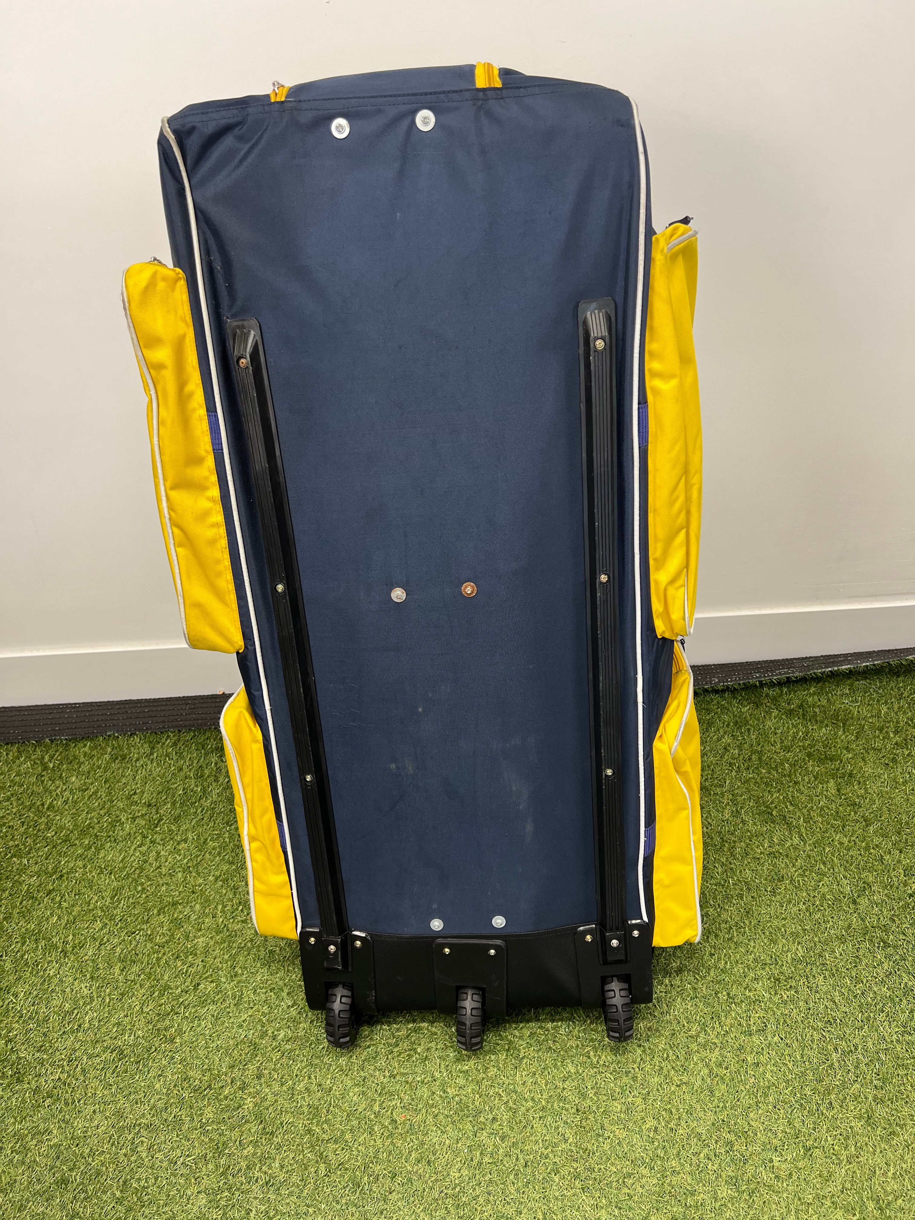 Back view of Punjab Royal wheeled cricket bag showing three trolley wheels and base support
