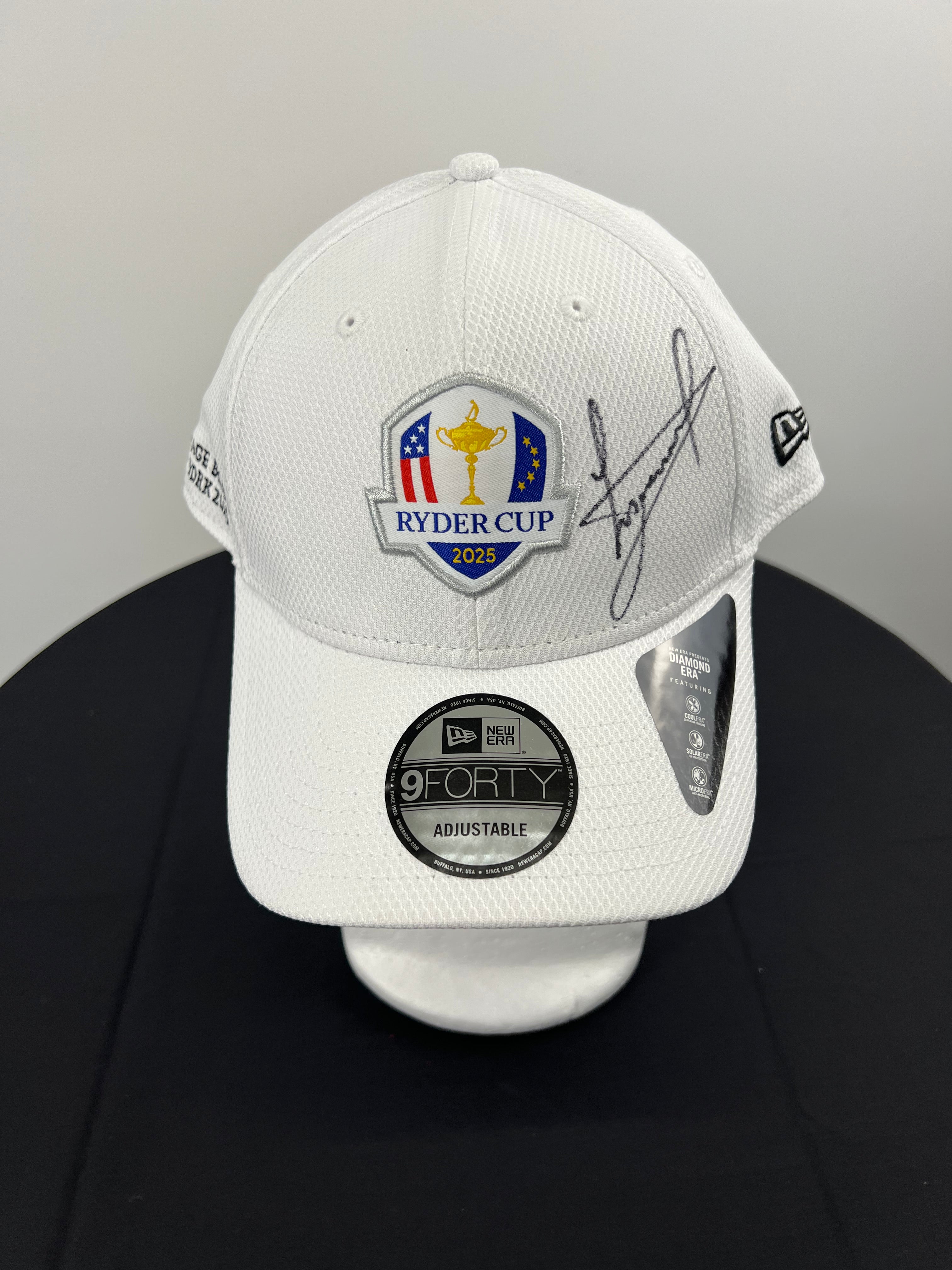 Front view of white Ryder Cup 2025 cap with embroidered logo and Luke Donald signature