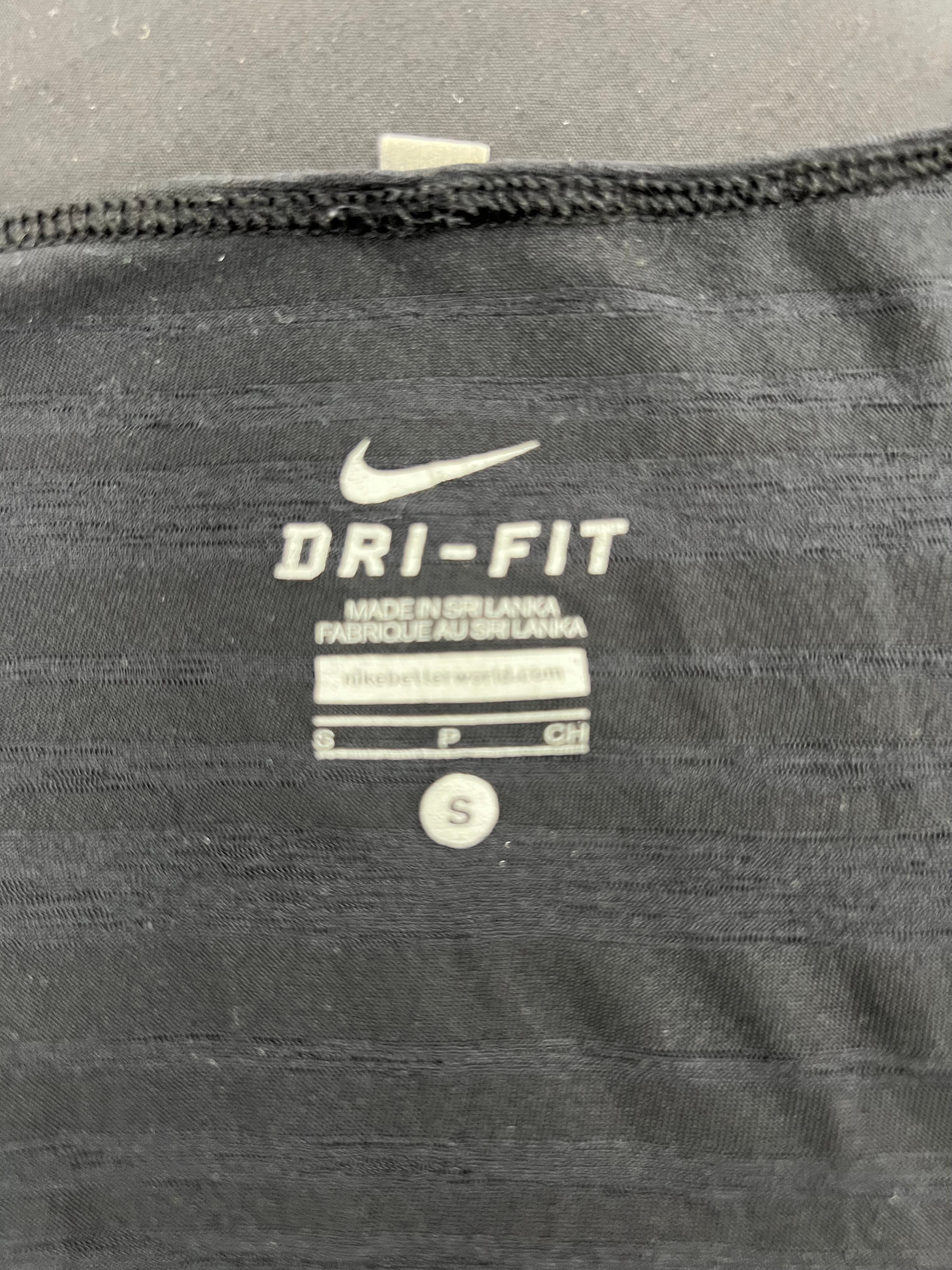 Close-up of Nike Dri-FIT logo and size label inside black sports vest