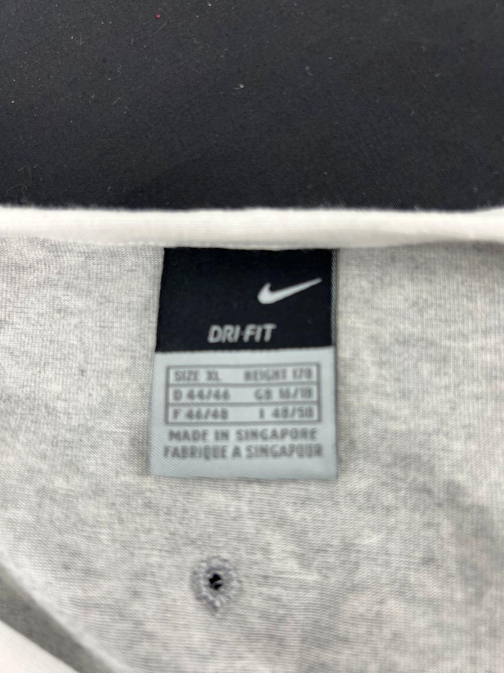 Close-up of Nike Dri-FIT label inside grey fabric training vest top size XL