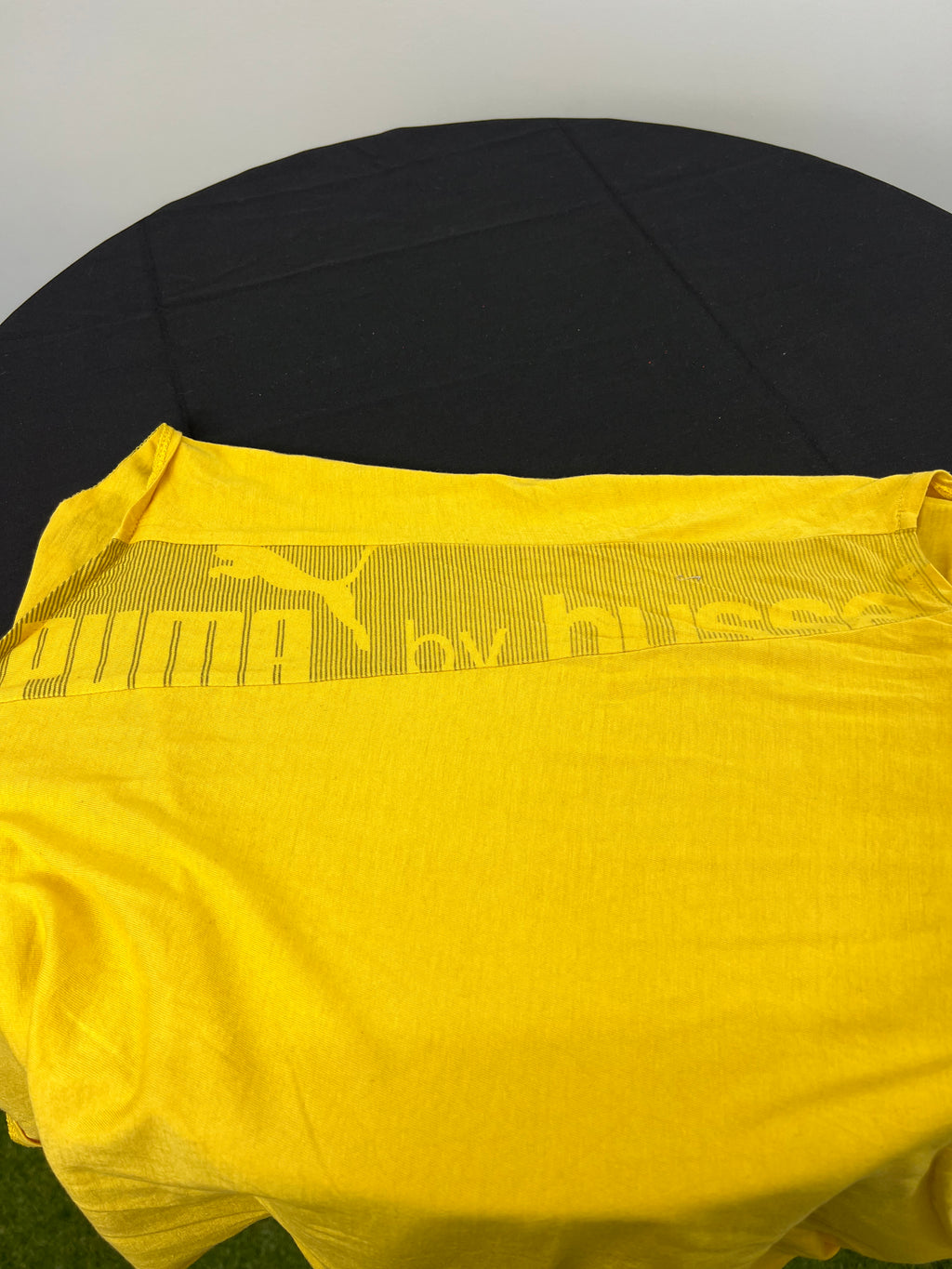 Close-up of Puma x Hussein Chalayan branding detail on the back of yellow sleeveless top