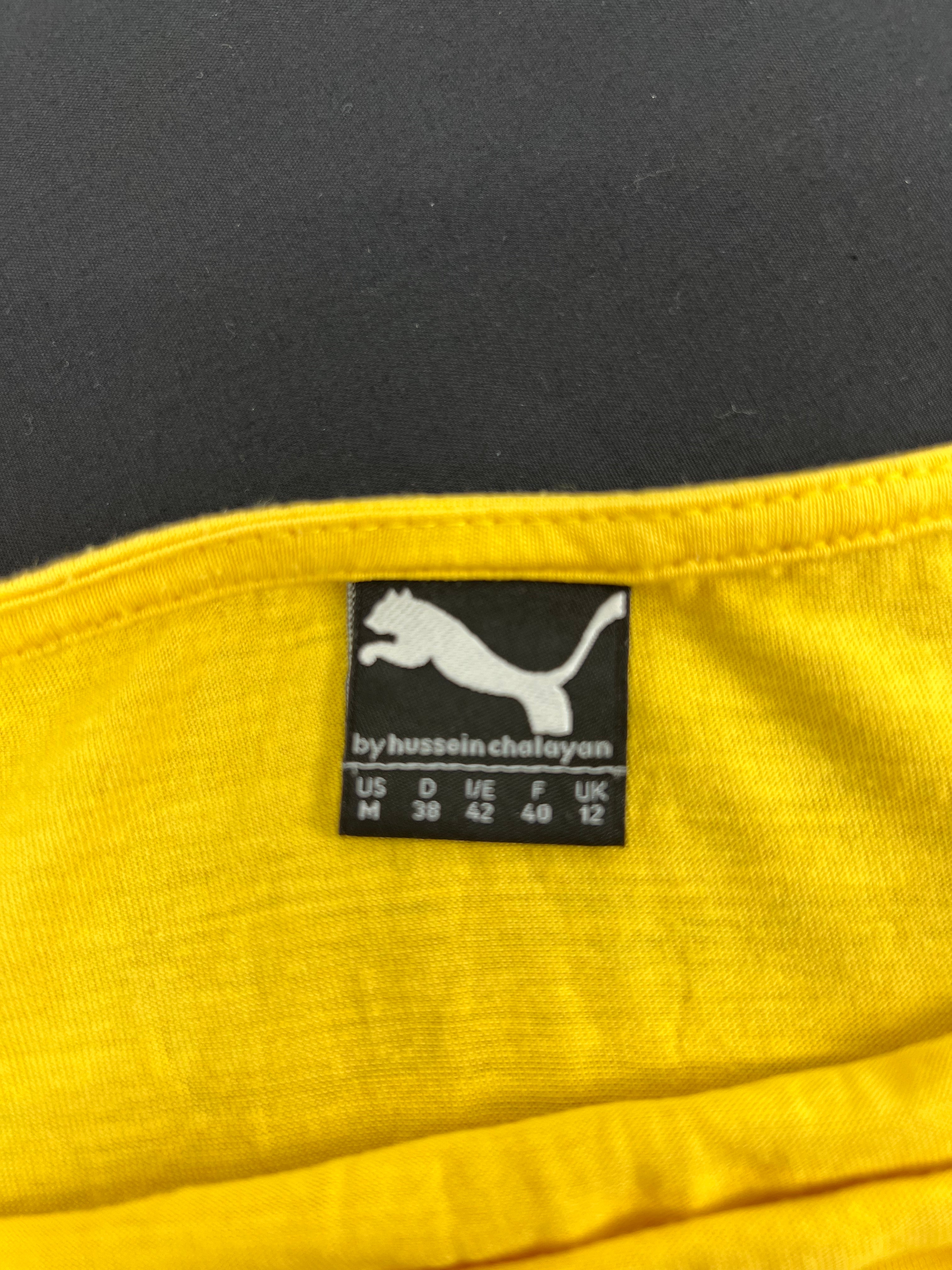 Label showing Puma by Hussein Chalayan with size information on yellow top