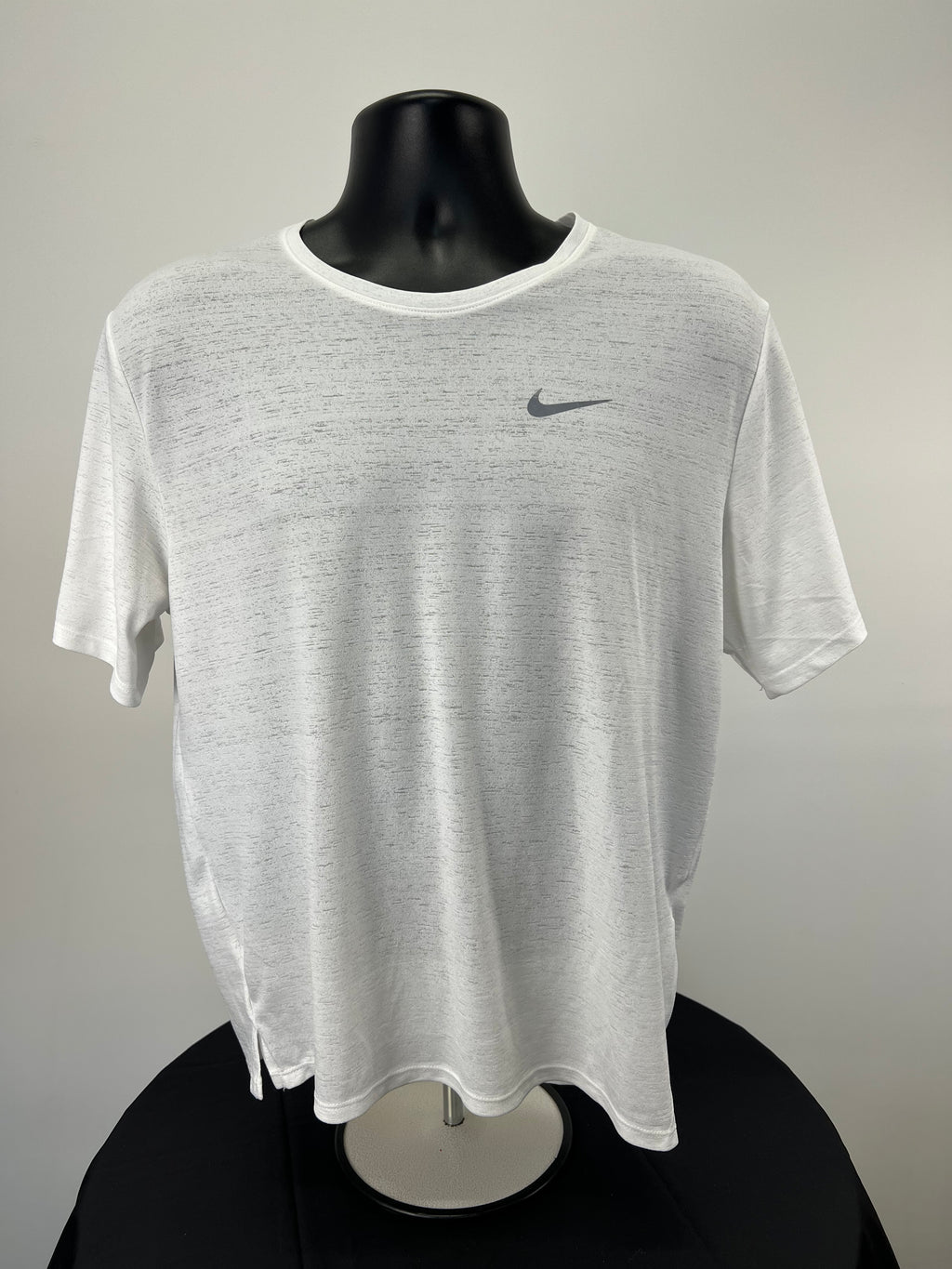 Front view of white Nike running t-shirt with grey Nike logo on black mannequin