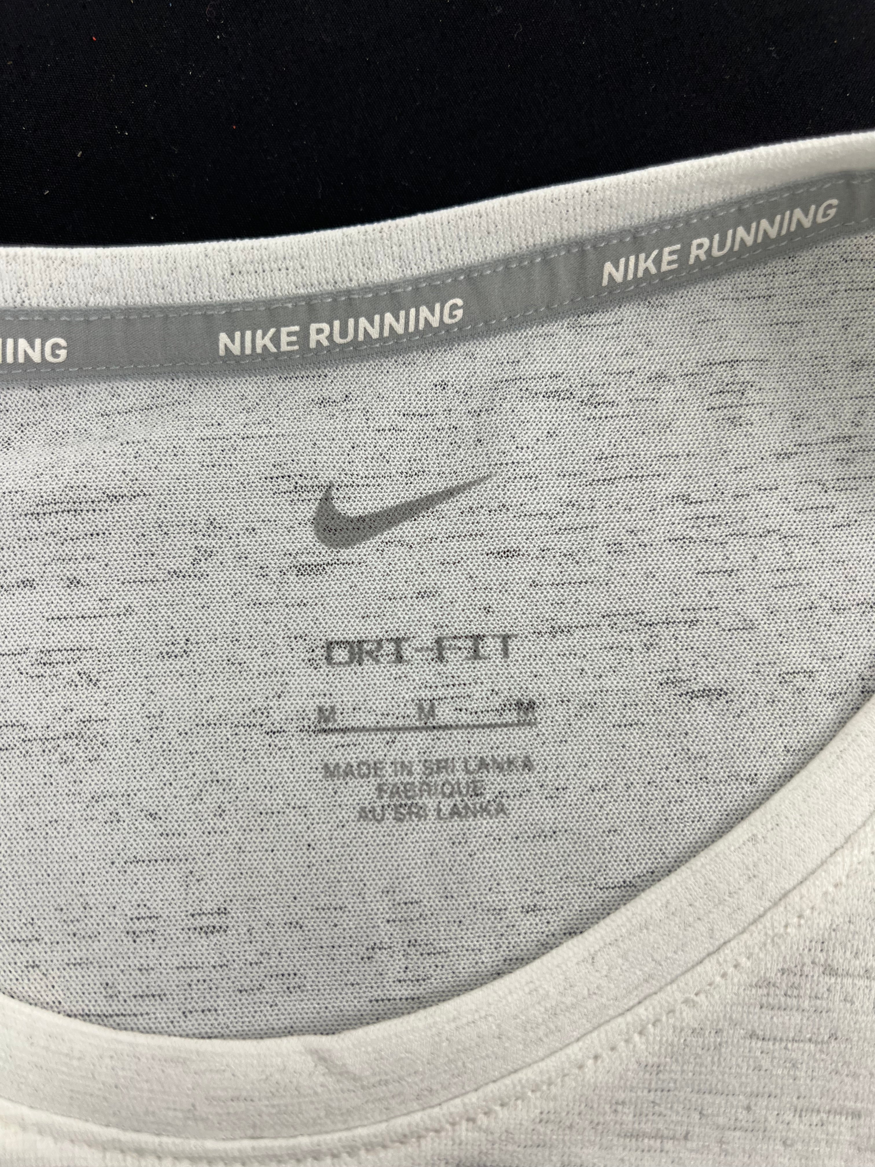Close-up of inner neckline of Nike running t-shirt showing Dri-FIT label and size medium