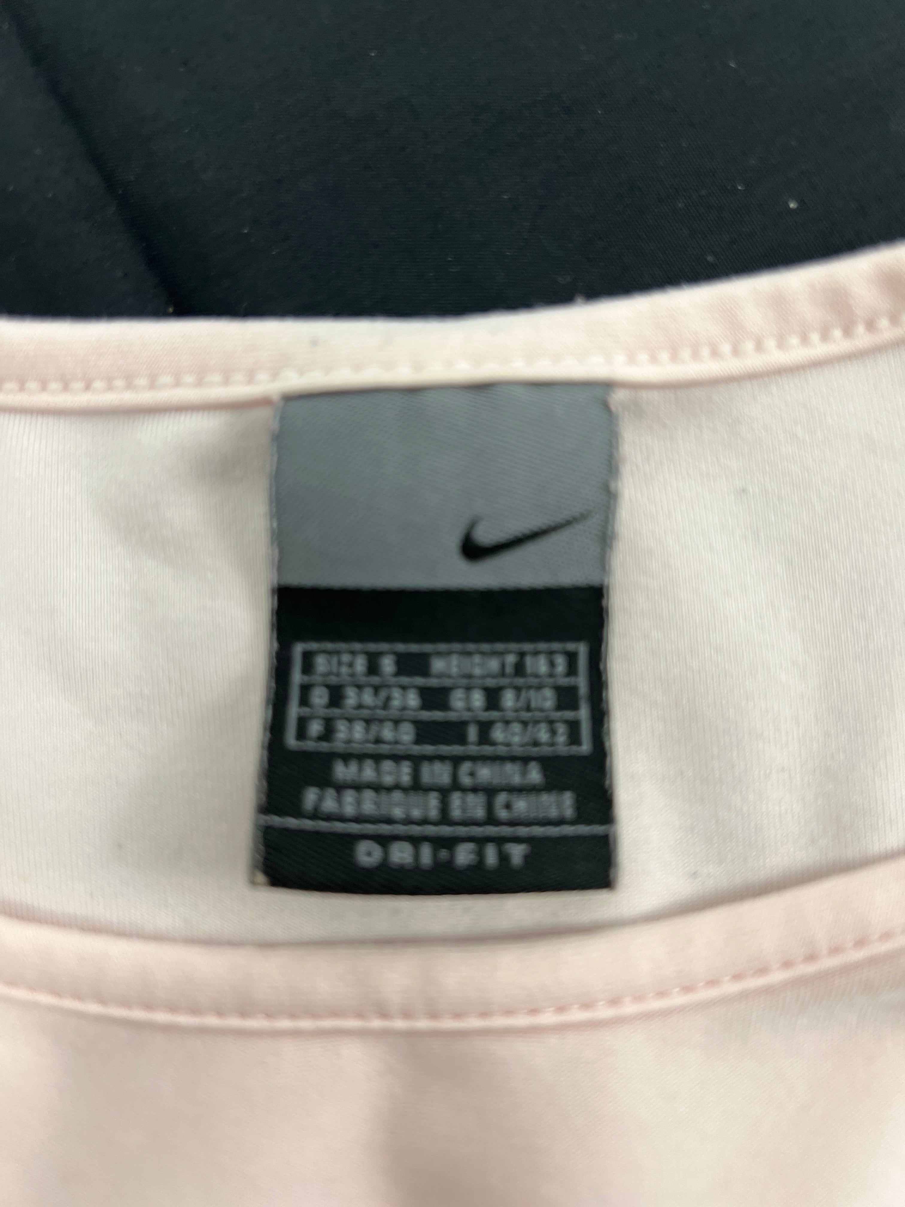 Close-up of Nike size and material label inside the light pink t-shirt