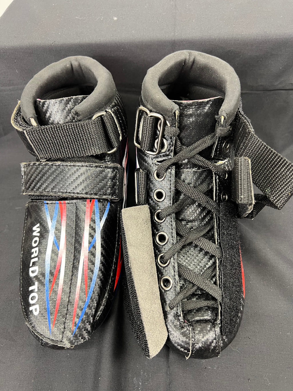 Top view of World Top speed skating boots with laces and straps visible, in carbon fibre material