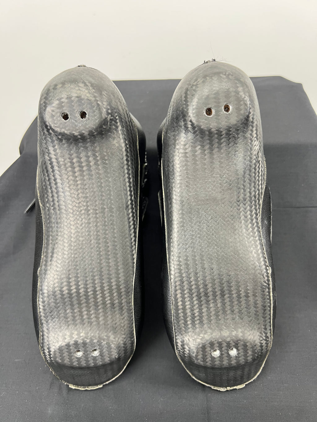 Bottom view of Go Faster short track speed skating boots showcasing carbon fibre soles without blades