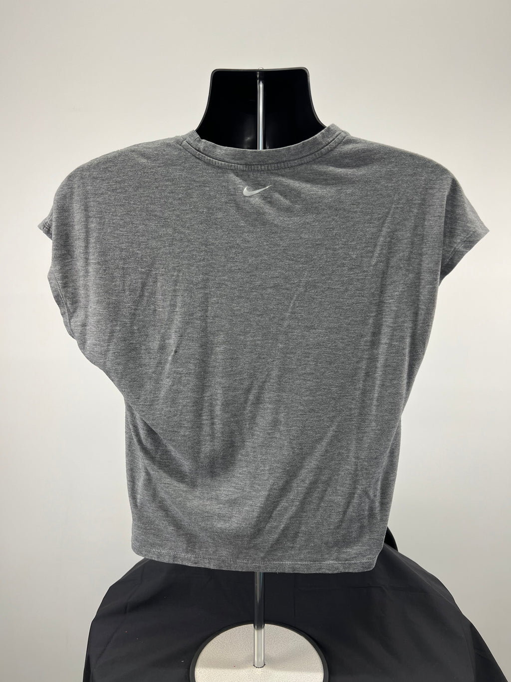 Back view of grey Nike t-shirt showing plain design with small Nike swoosh logo near neck