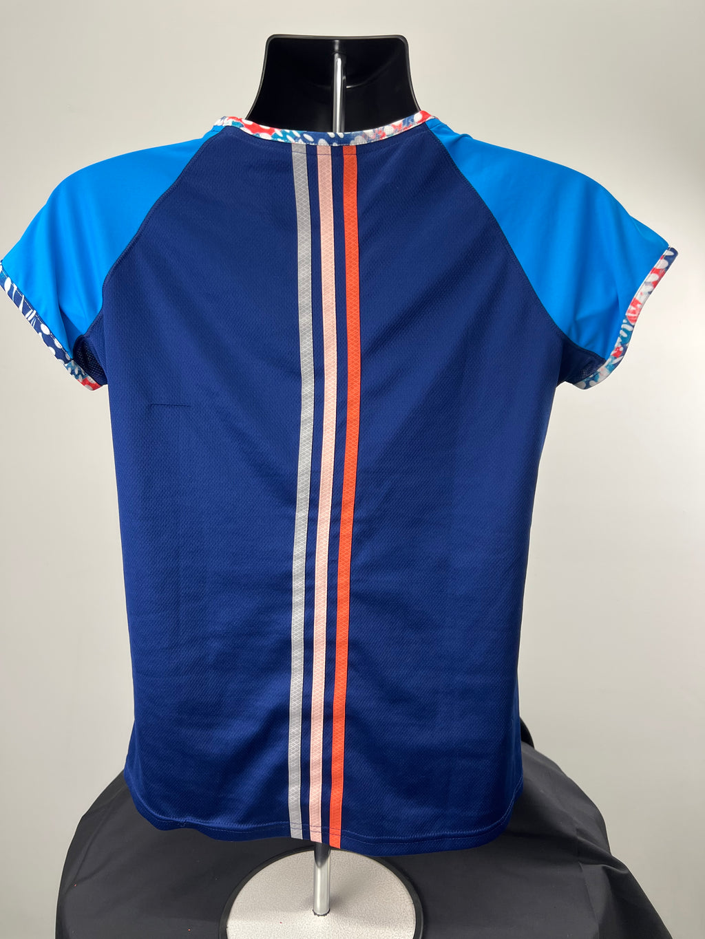 Back view of Adidas running t-shirt showing three vertical stripes in red, white and grey on navy blue fabric