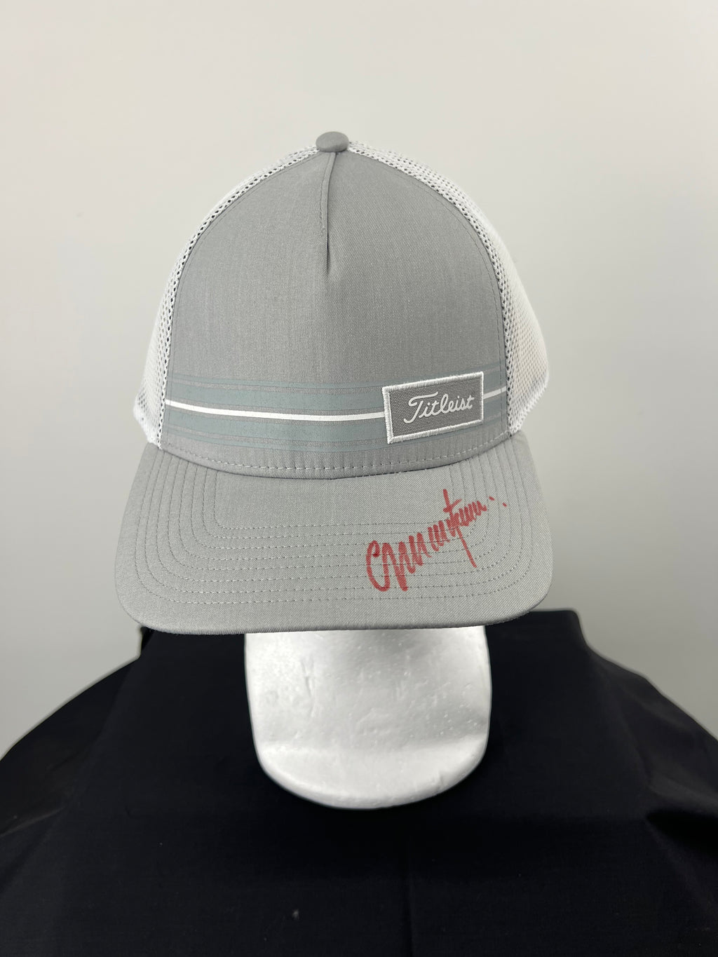Front view of grey Titleist cap signed by Colin Montgomerie on the brim in red ink