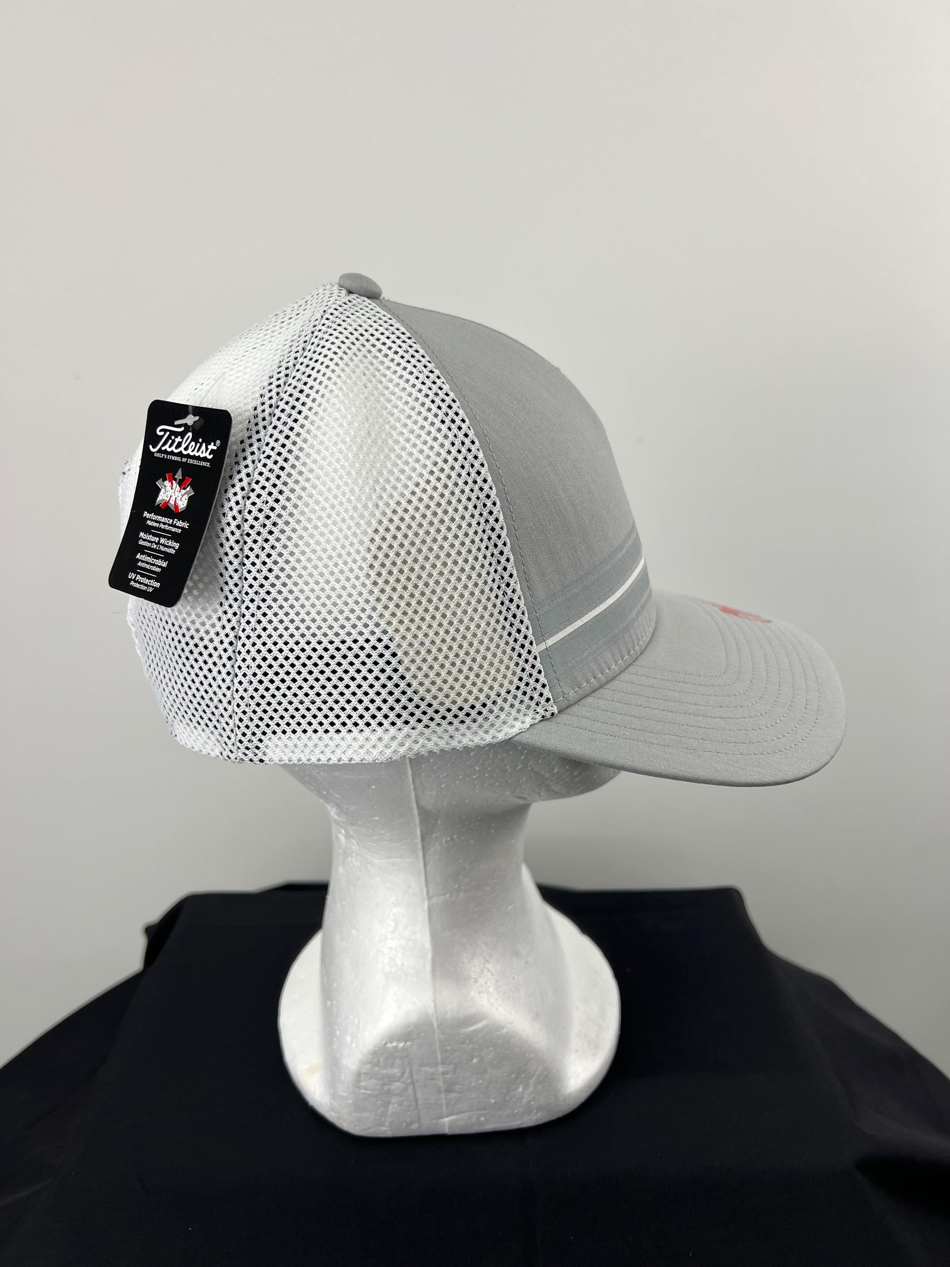Side view of grey and white mesh Titleist cap showing adjustable snapback and tag