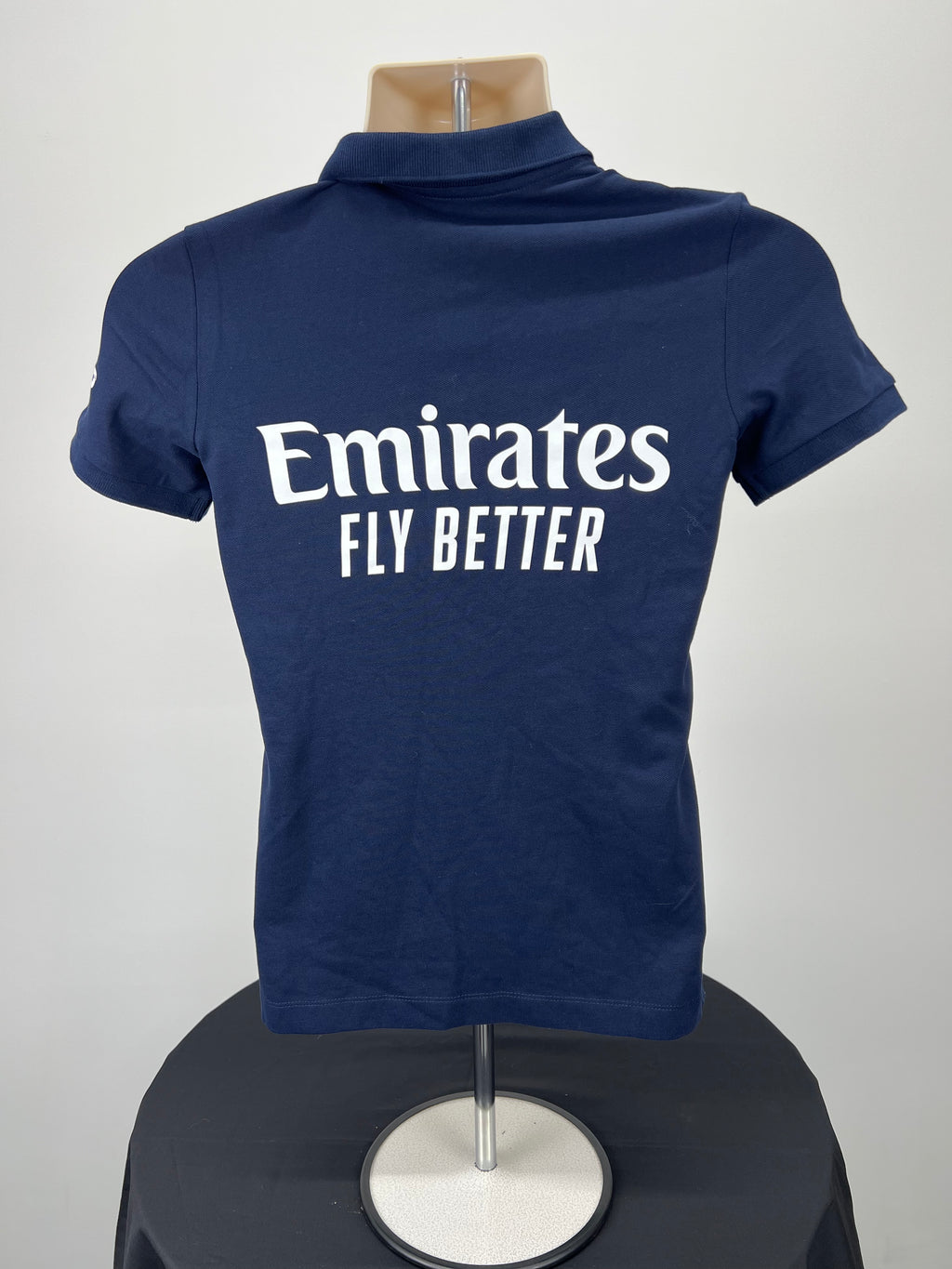 Back view of navy blue Emirates Fly Better logo on women's polo shirt