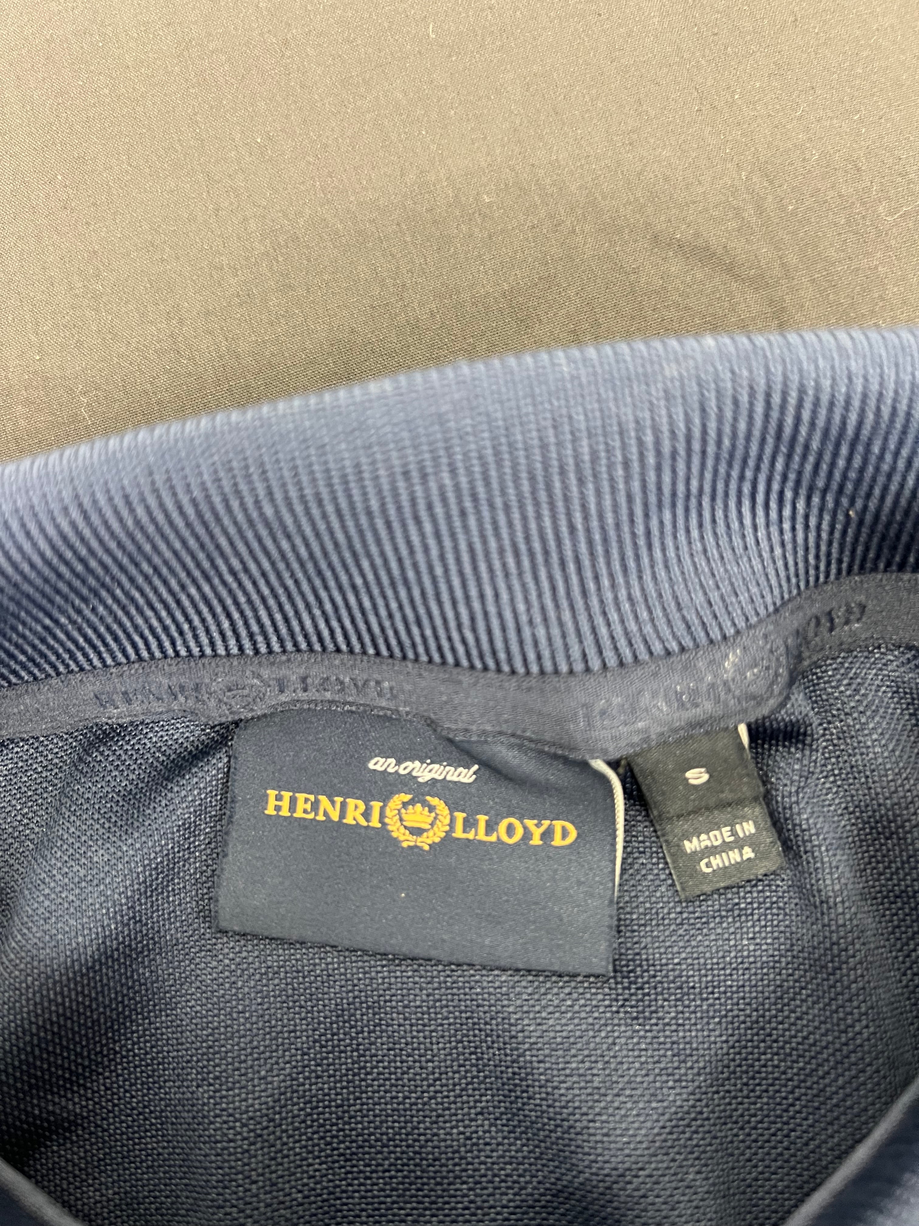 Close-up of Henri Lloyd brand label and 'made in China' fabric tag inside collar of navy polo