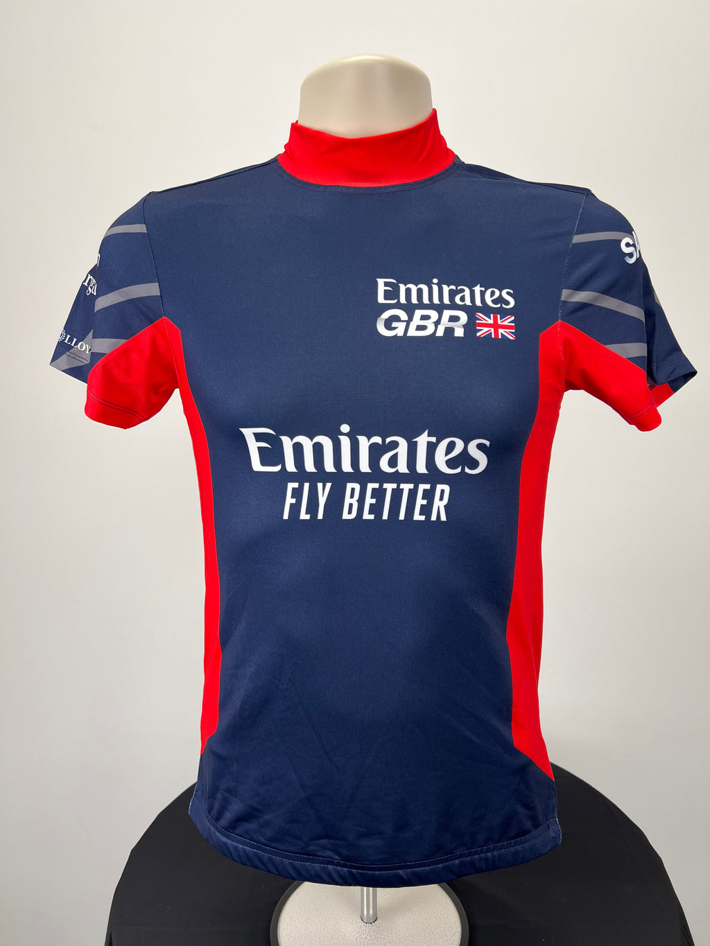 Front view of Emirates Team GBR SailGP rash vest in navy blue with red accents and Emirates Fly Better logo