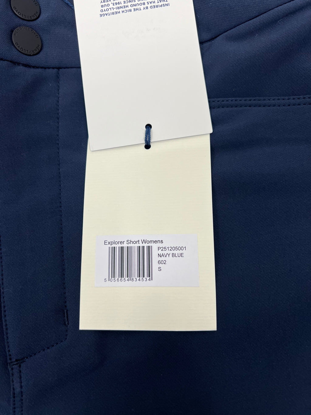 Close-up of navy fabric tag showing 'Explorer Short Womens', size S and navy blue colour