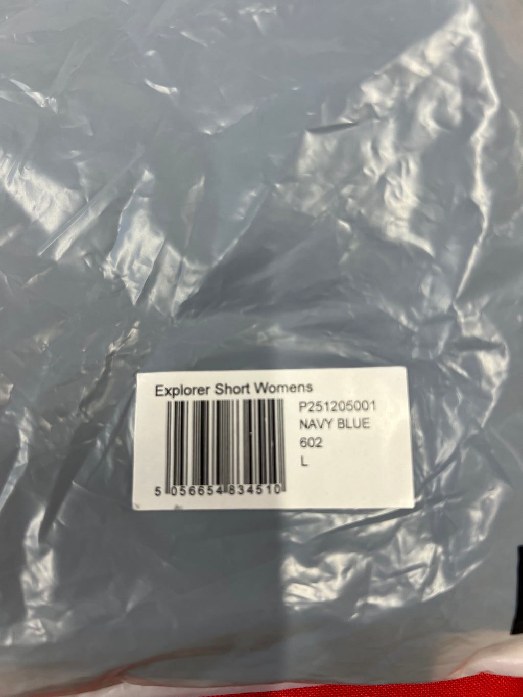 Packaged navy women's explorer shorts with barcode label showing product name and size L