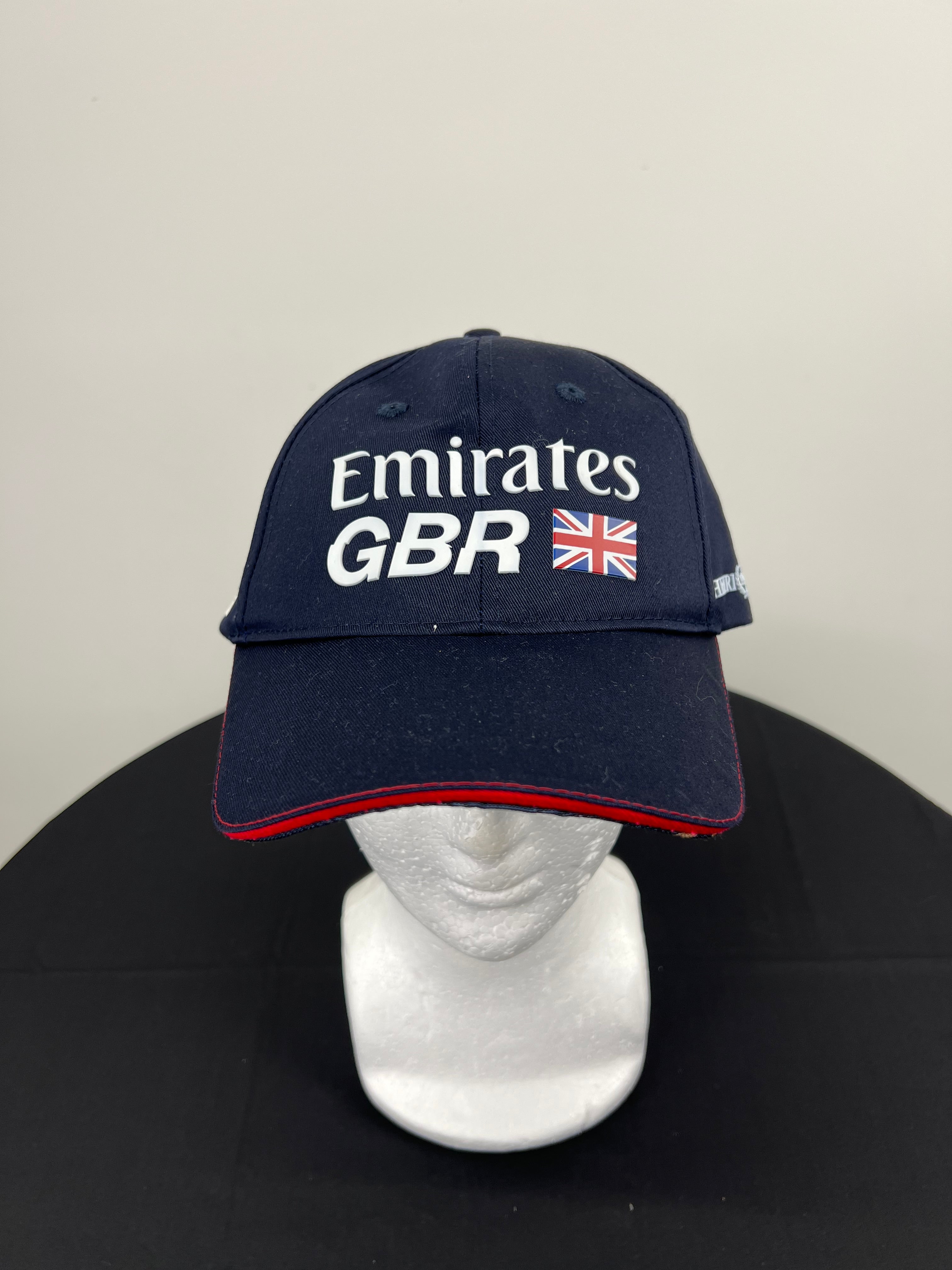 Front view of navy blue Emirates Team GBR x Henri Lloyd cap with UK flag and white logo