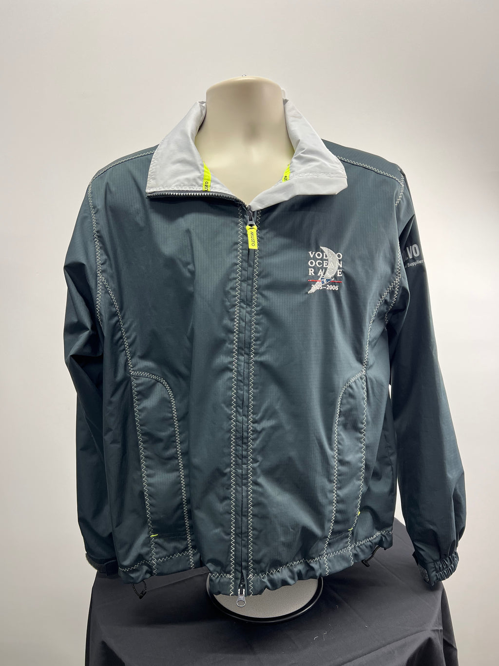Front view of Women’s Musto Volvo Ocean Race jacket in dark grey with white collar and yellow zipper pull