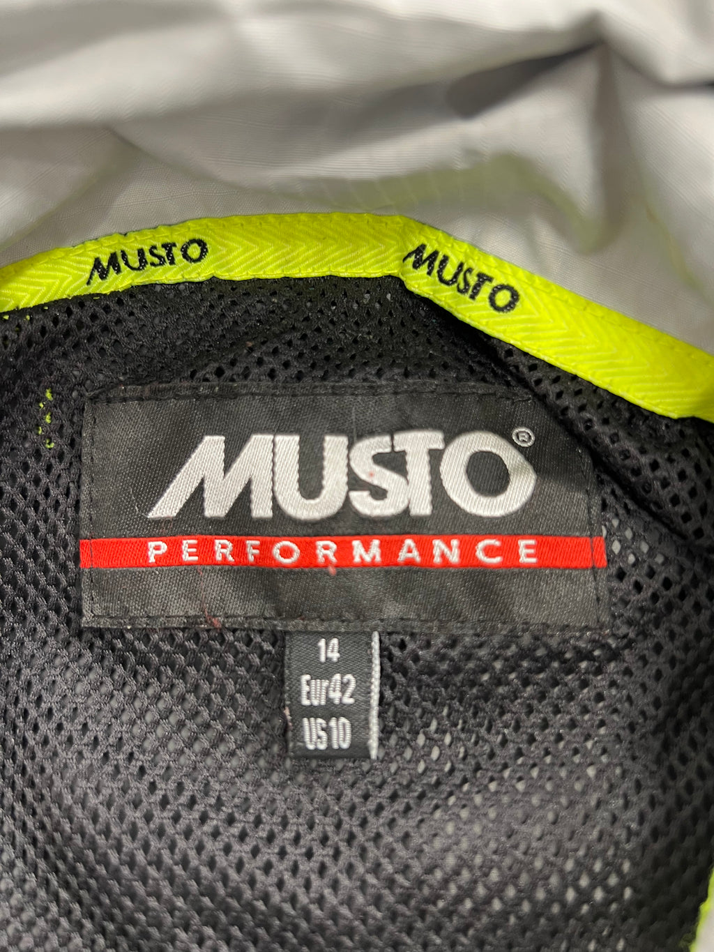 Close-up of internal Musto Performance label with size 14 EUR 42 US 10 inside the jacket