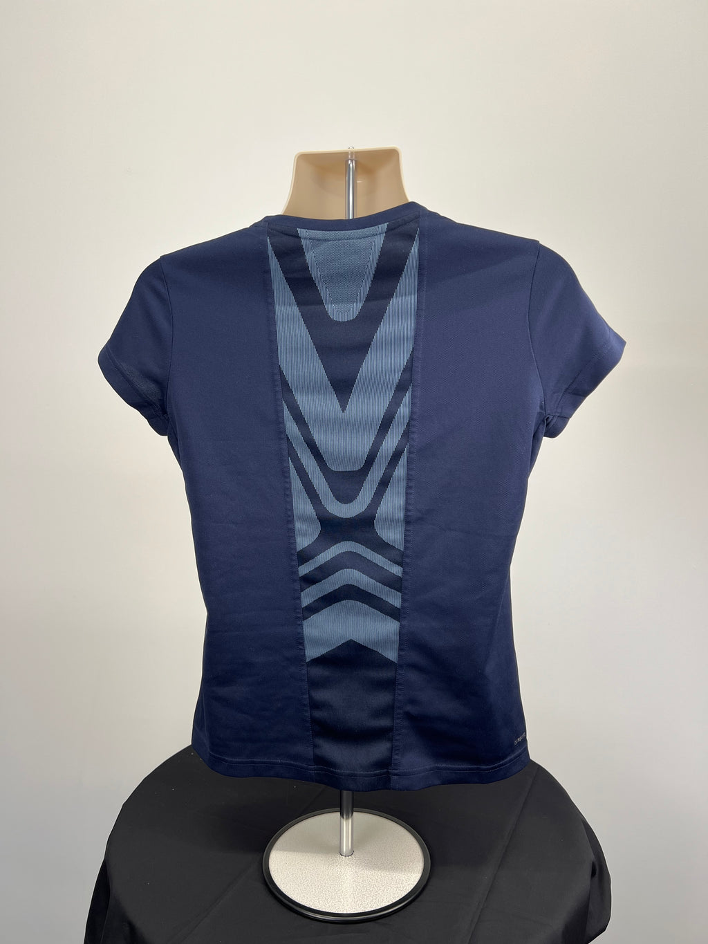 Back view of women's Adidas t-shirt showing geometric design panel and reflective shoulder stripes