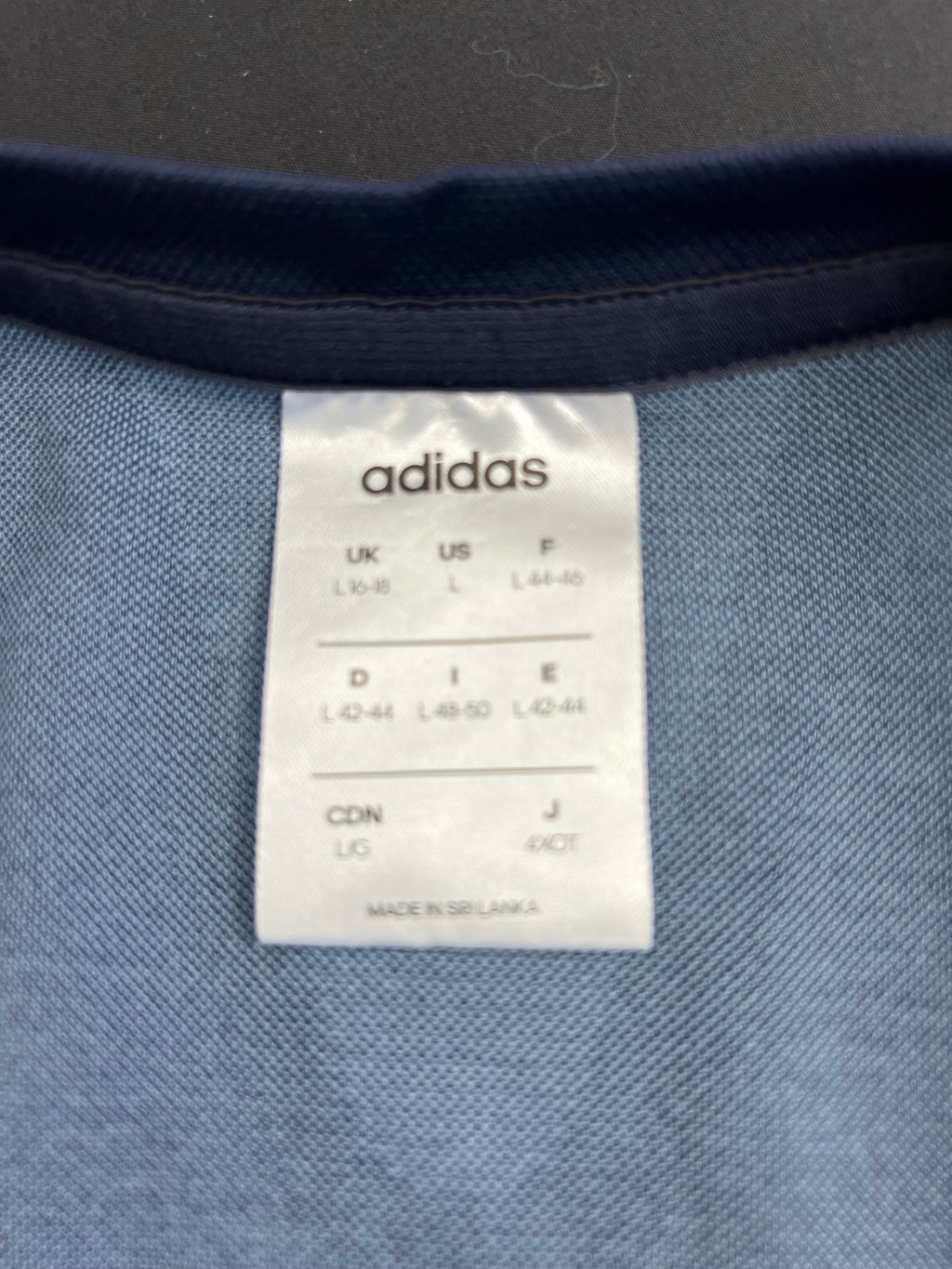 Close-up of Adidas size label inside the t-shirt showing UK size 16-18