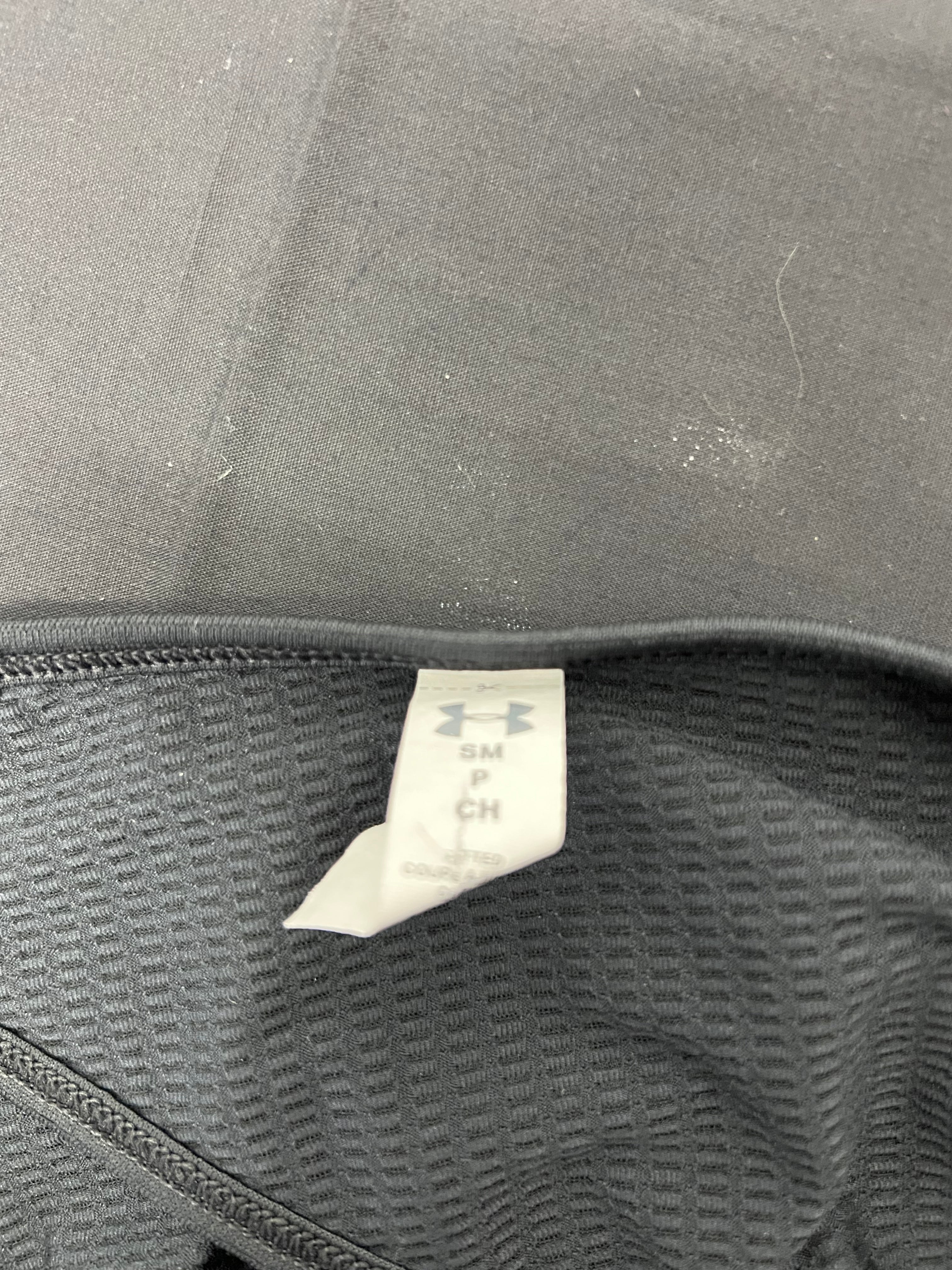 Close-up of size tag inside under armour women's black T-shirt showing size small