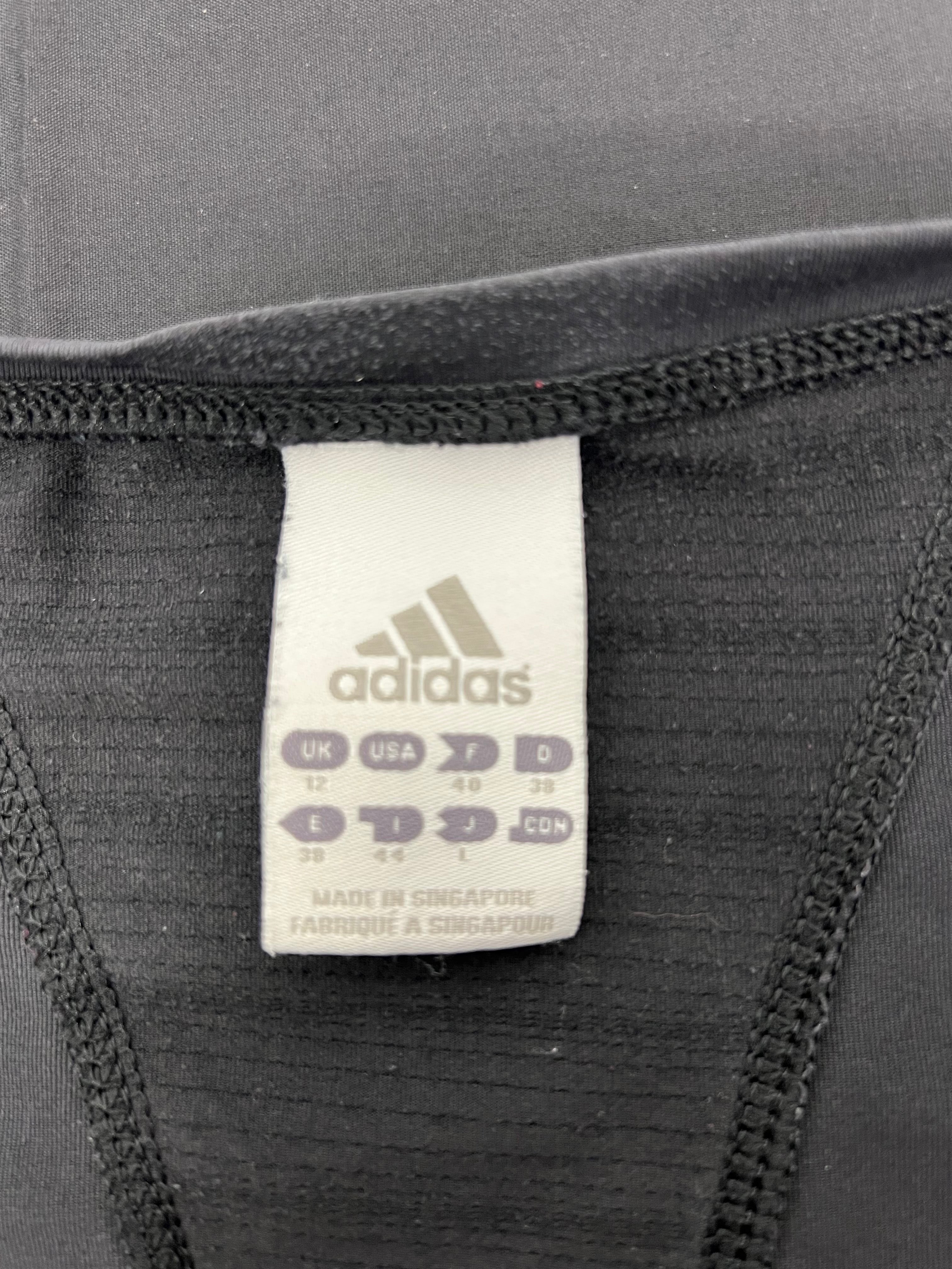 Close-up of Adidas size tag inside the black tunic length t-shirt