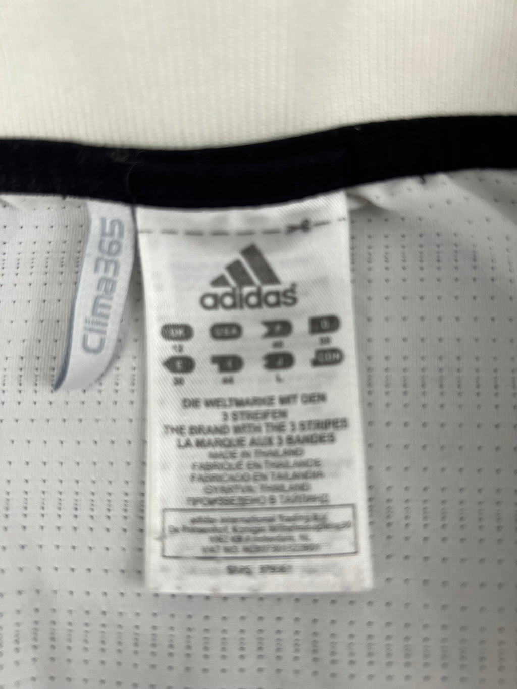 Close-up of the adidas label and Clima365 tag inside the white tennis polo top