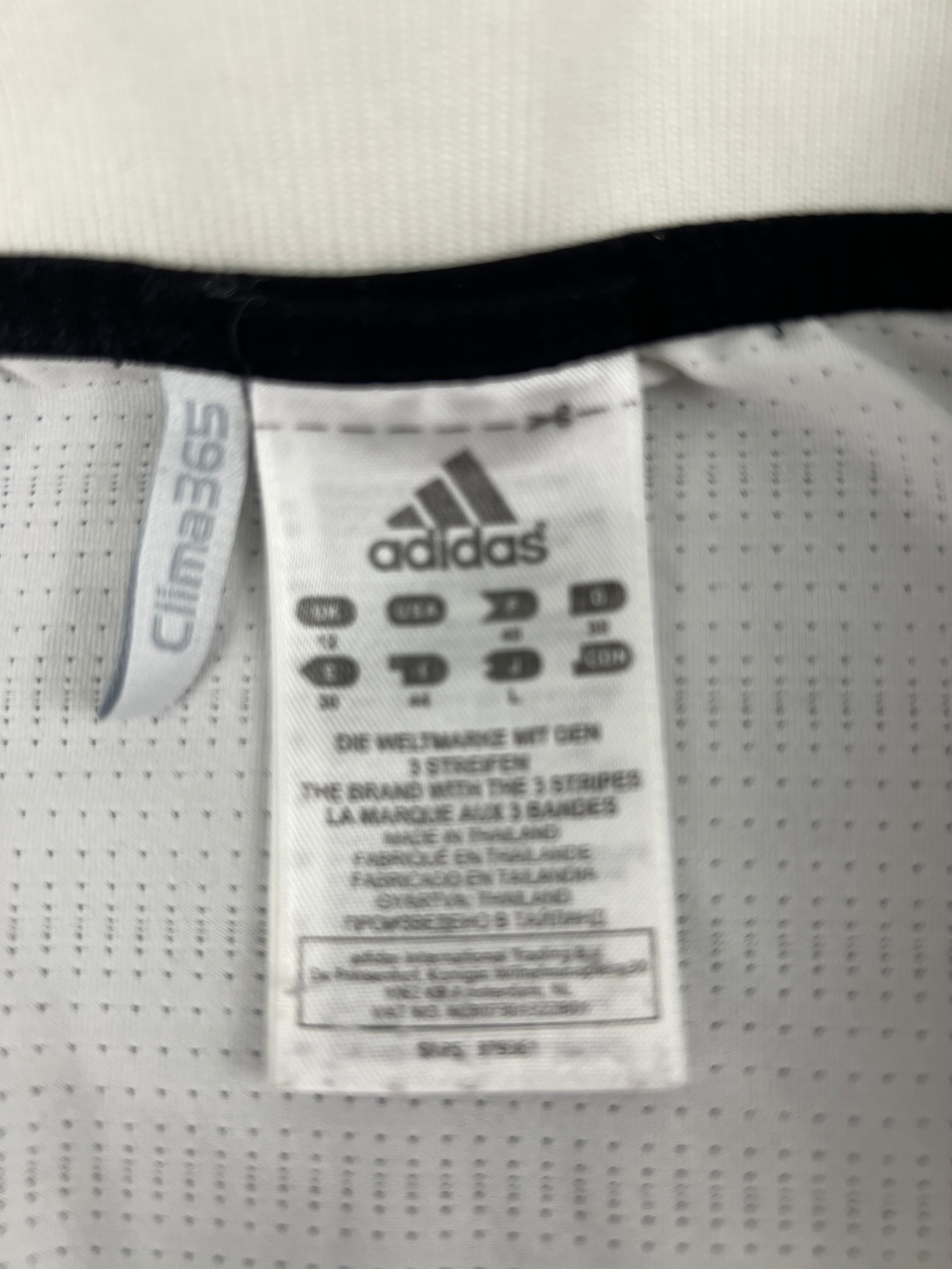 Close-up of the adidas label and Clima365 tag inside the white tennis polo top