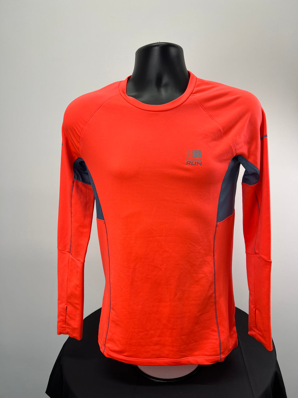 Front view of Karrimor Xlite long sleeve base layer top in bright red with dark grey mesh panels on sides and underarms