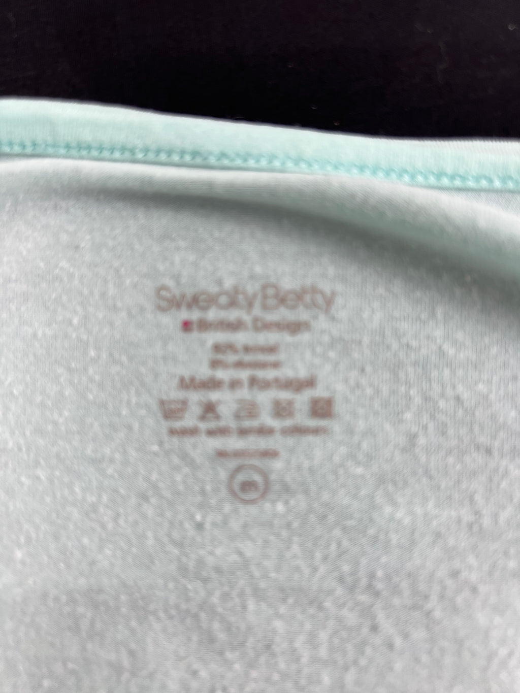 Close-up of inner label of Sweaty Betty top showing material and care instructions