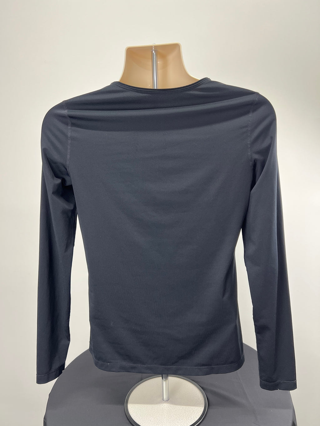 Back view of Nike women's black long sleeve top on mannequin