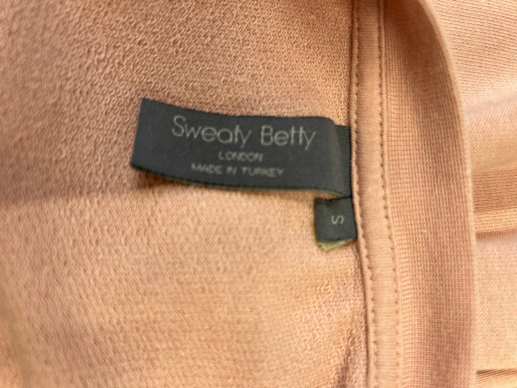 Close-up of Sweaty Betty brand label inside light pink sweatshirt