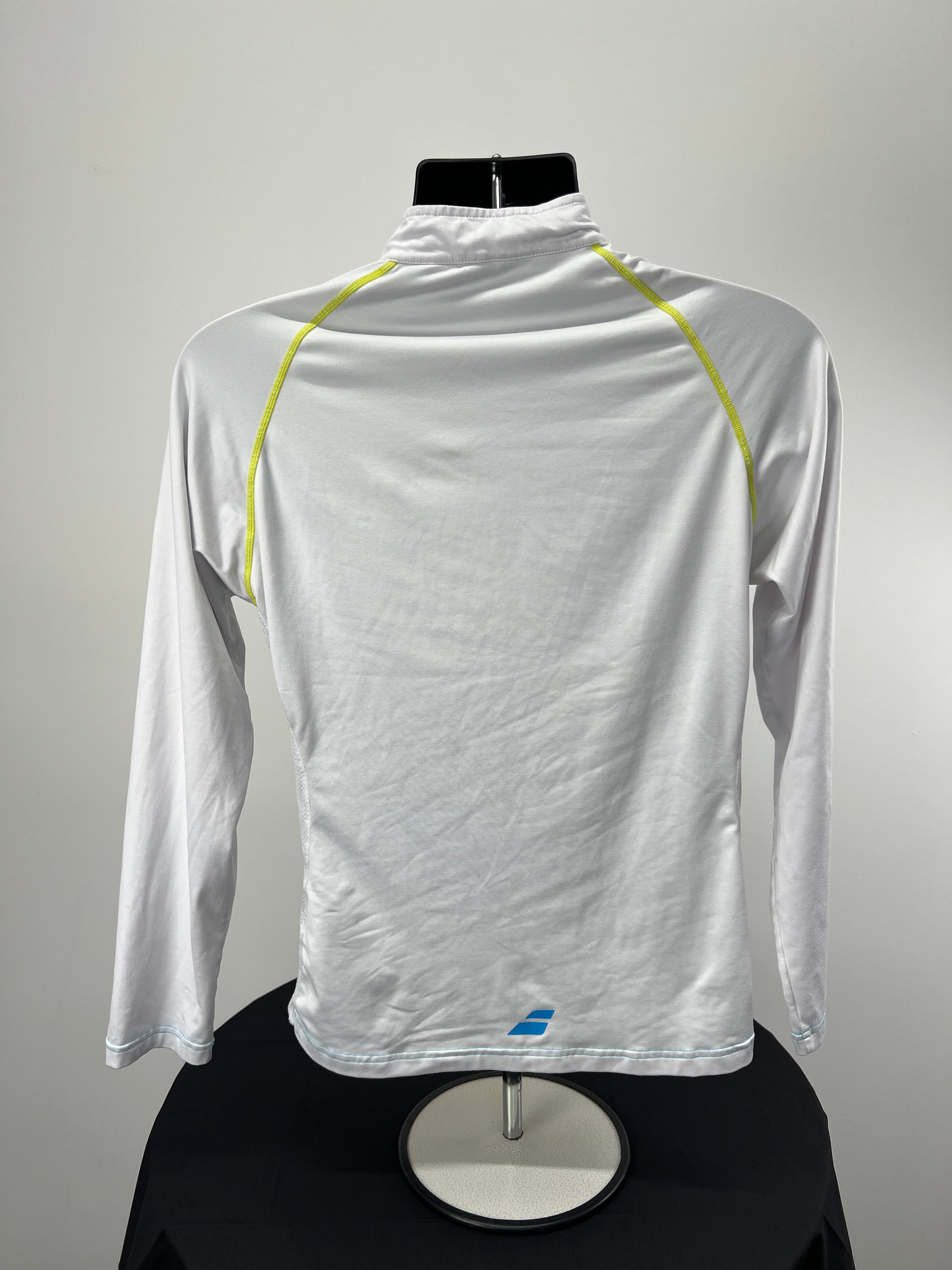 Back view of Babolat white long sleeve tennis top showing neon yellow raglan seams and bottom logo