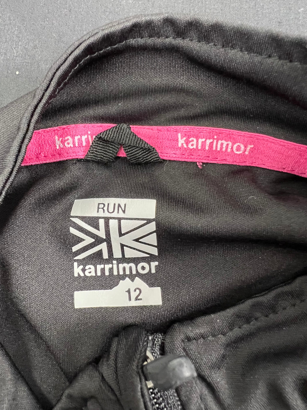 Close-up of Karrimor brand label and size 12 tag inside the black running top