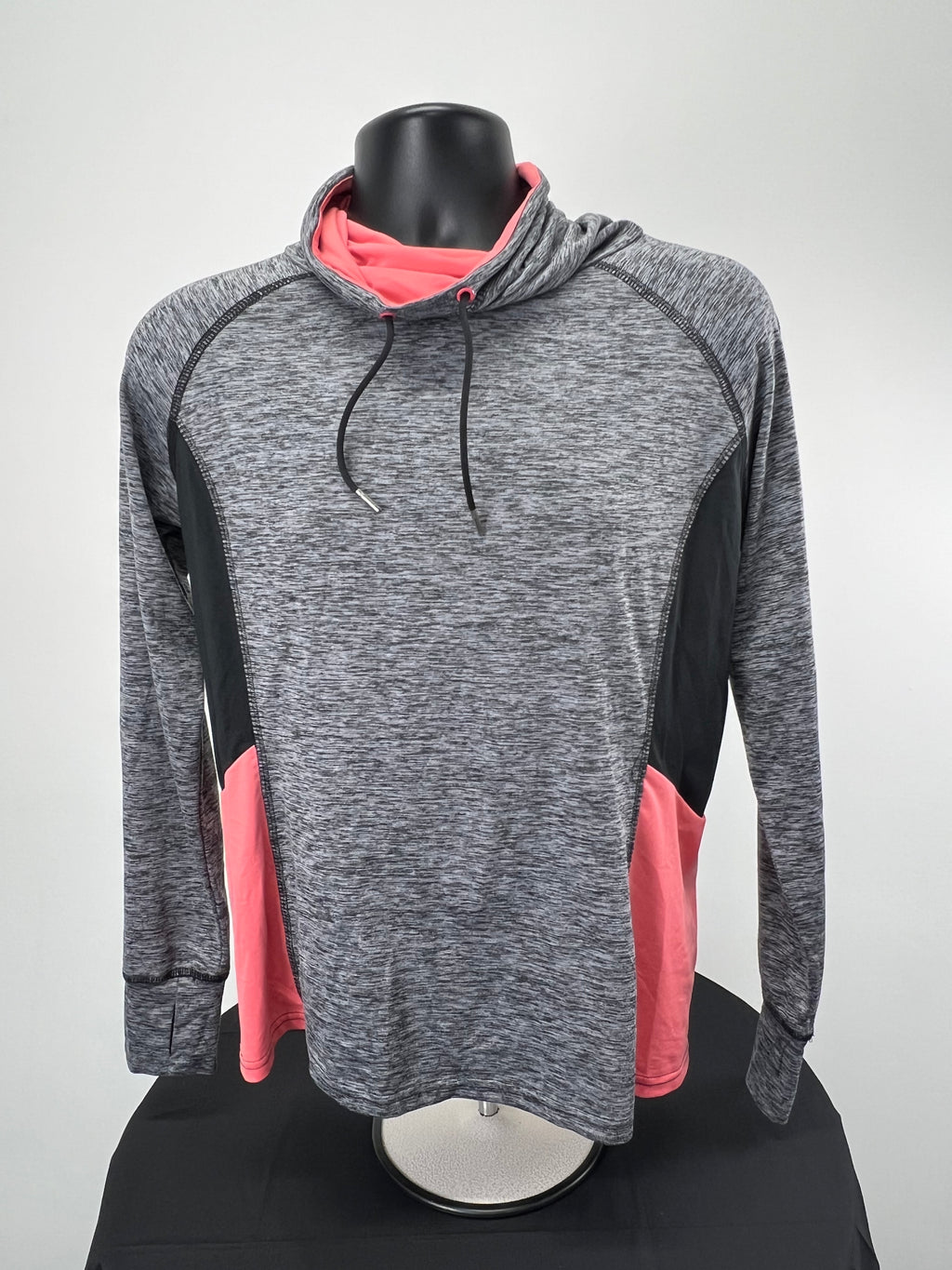 Front view of women's Crane long sleeve top with grey marled fabric, black side panels, and pink accents, featuring a small cowl neck with black drawstrings