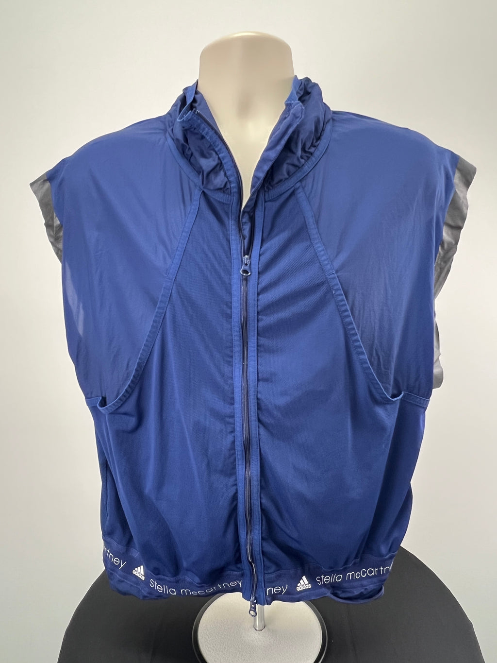 Front view of Adidas x Stella McCartney navy blue sleeveless full zip running top on mannequin