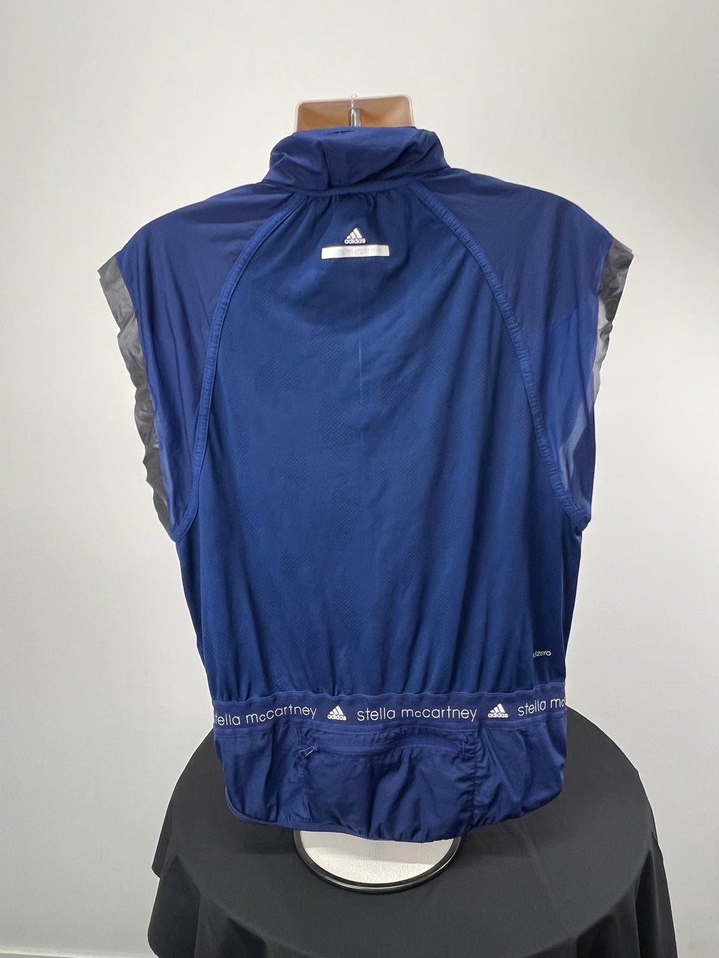 Back view of Adidas x Stella McCartney navy blue sleeveless full zip running top showing reflective logo and mesh fabric