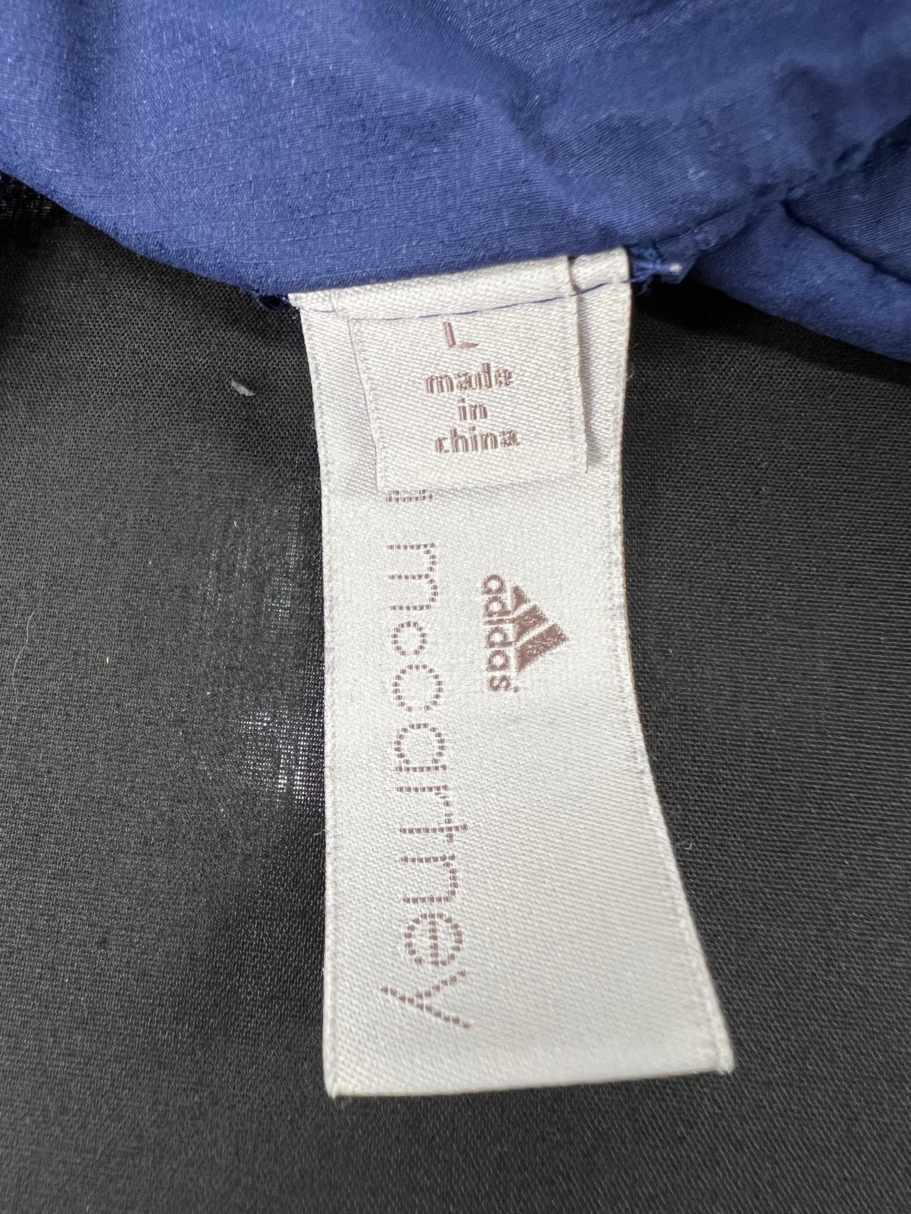 Close-up of Adidas x Stella McCartney label inside the navy blue sleeveless running top size L