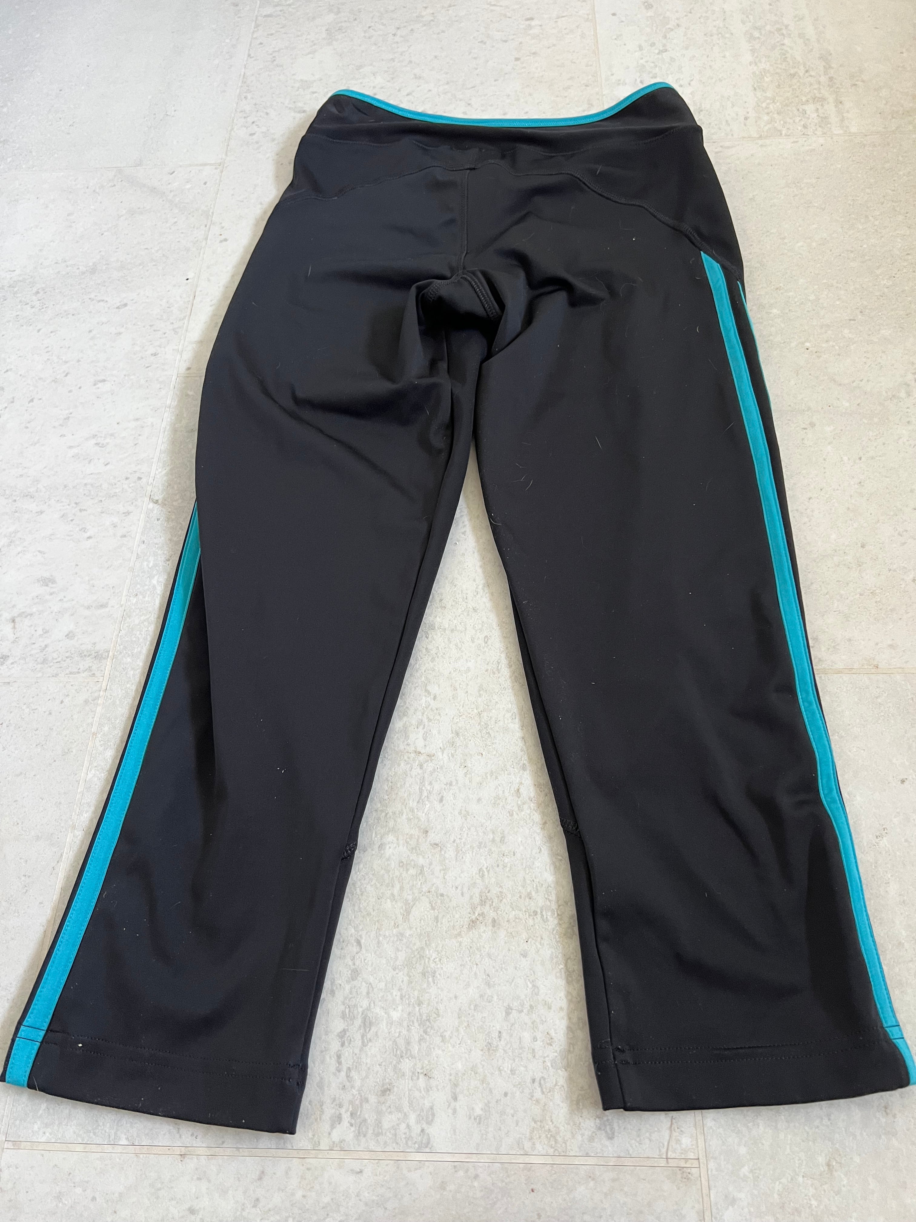 Back view of Adidas black cropped leggings with turquoise stripe detailing