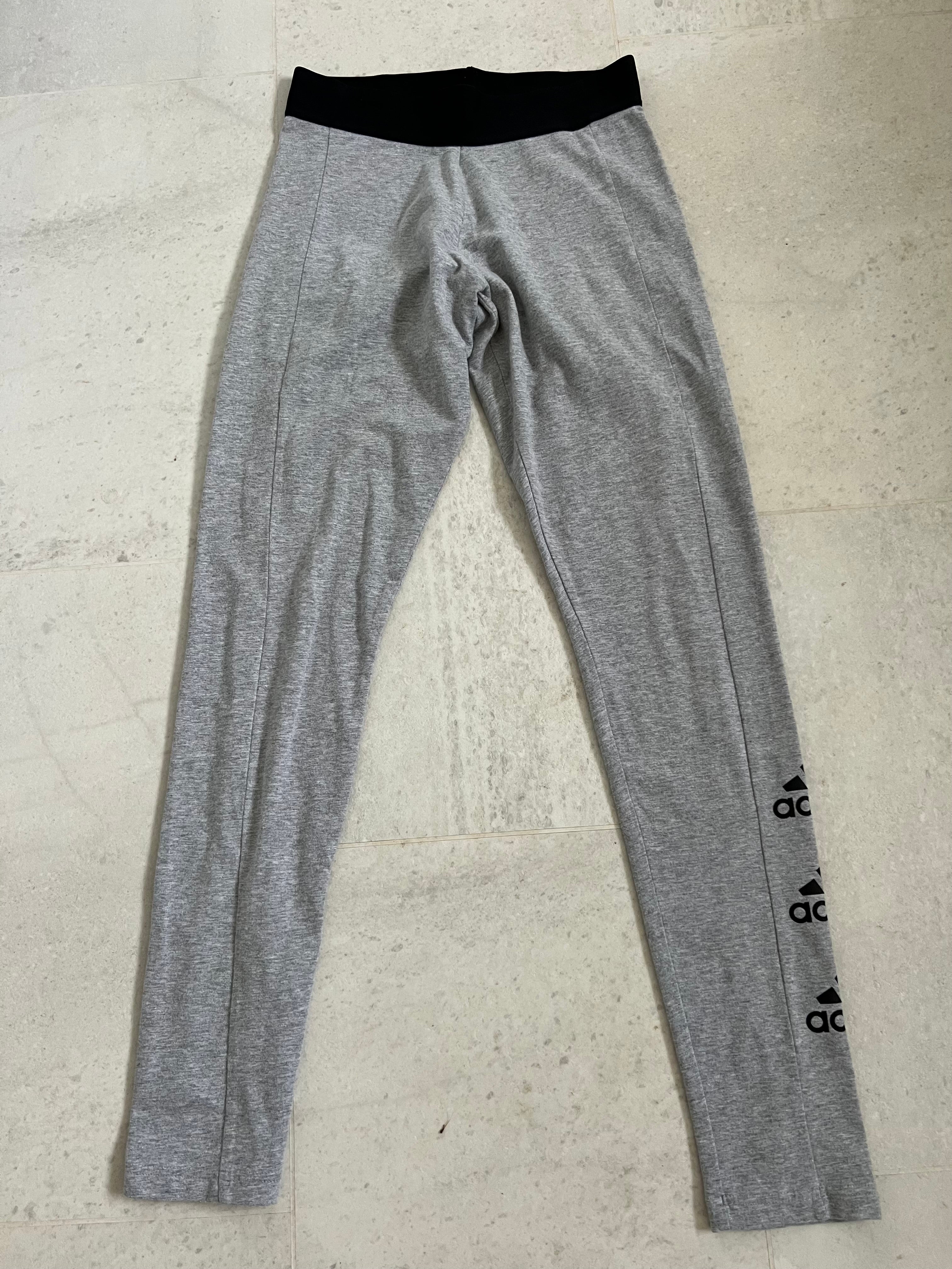 adidas grey leggings laid flat with black elasticated waistband and side logo print