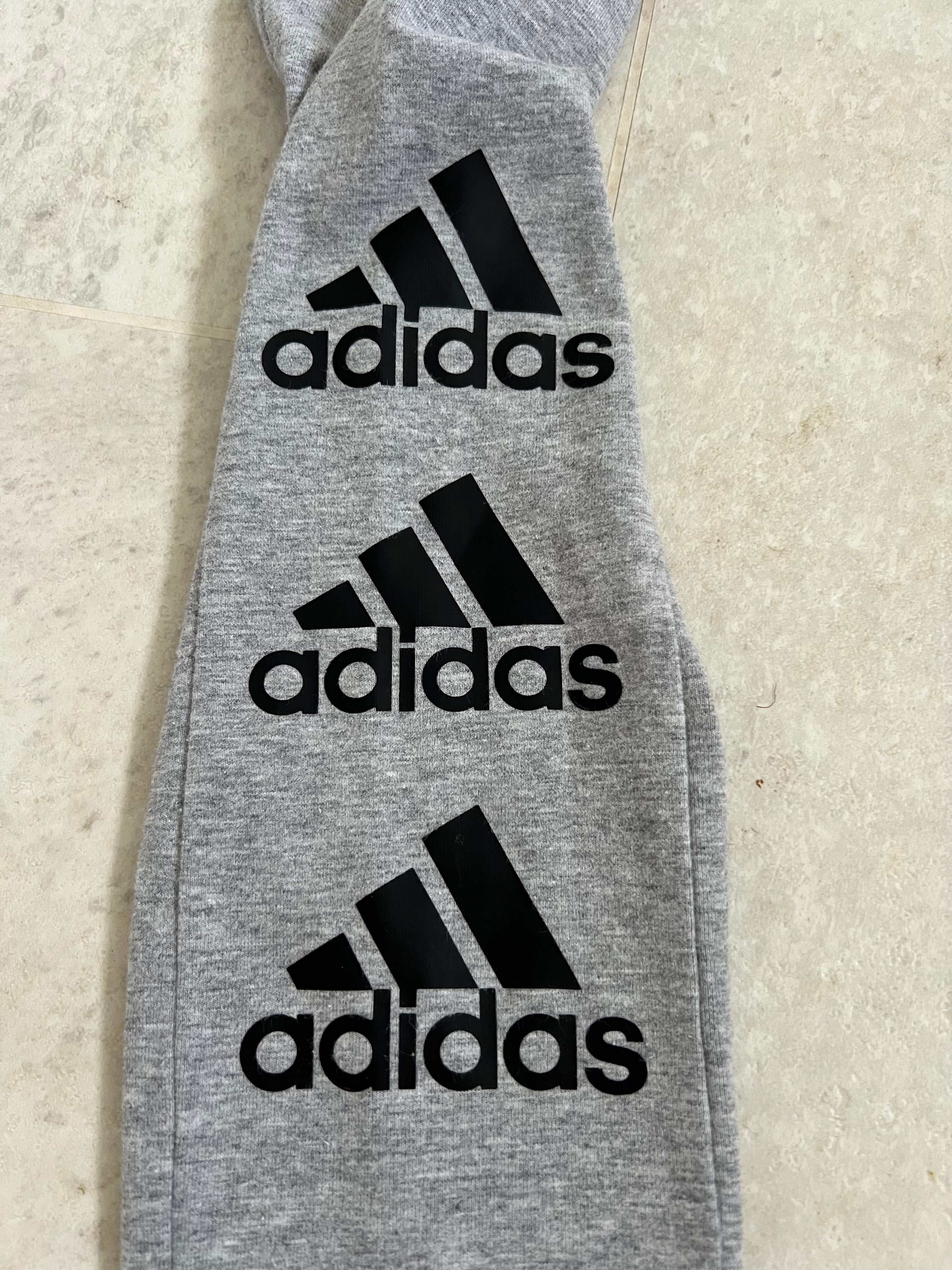 close-up of adidas black logo prints on grey leggings fabric