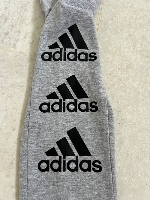 close-up of adidas black logo prints on grey leggings fabric