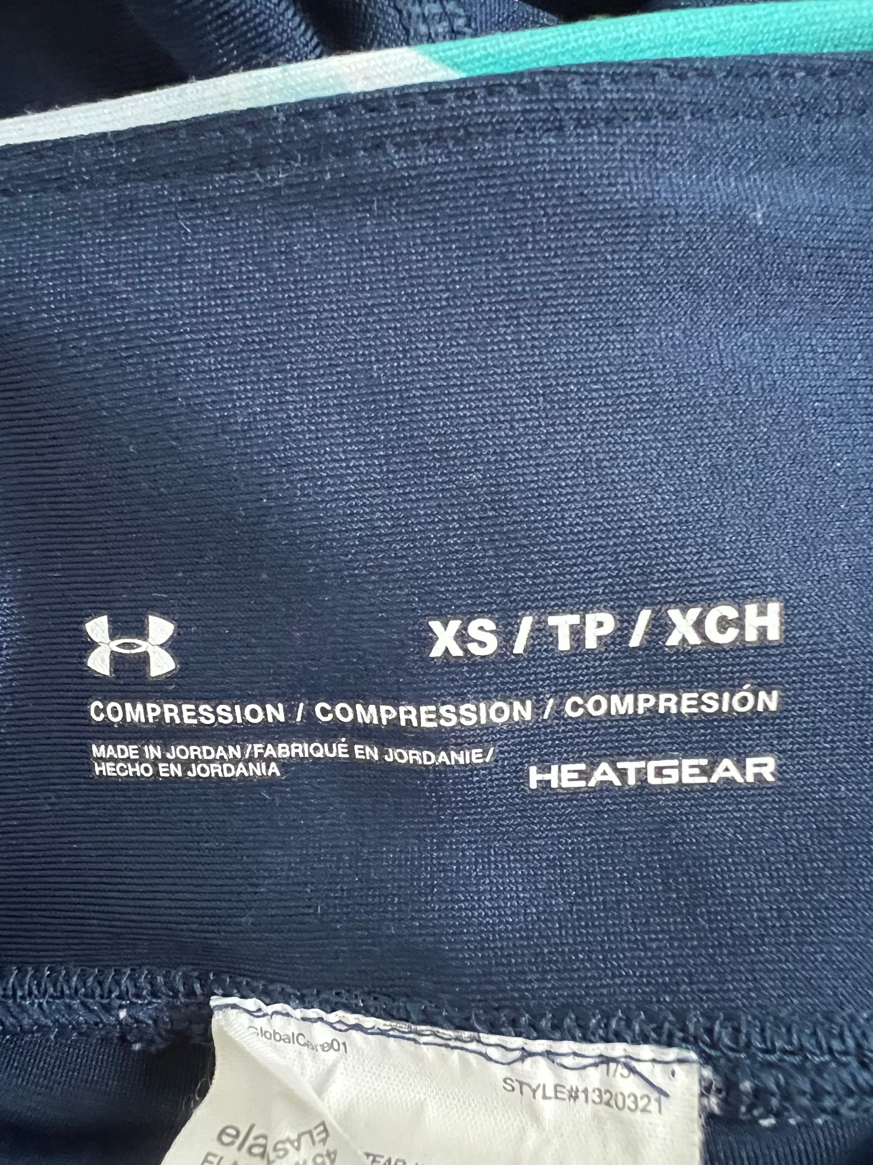 Size and material label inside Under Armour cropped compression leggings with HeatGear branding