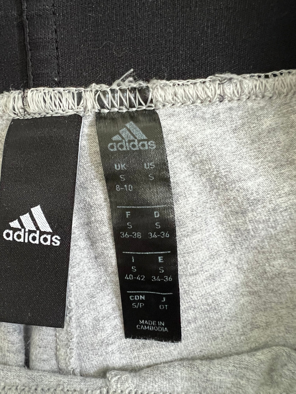inside label of adidas grey leggings showing size S and fabric details
