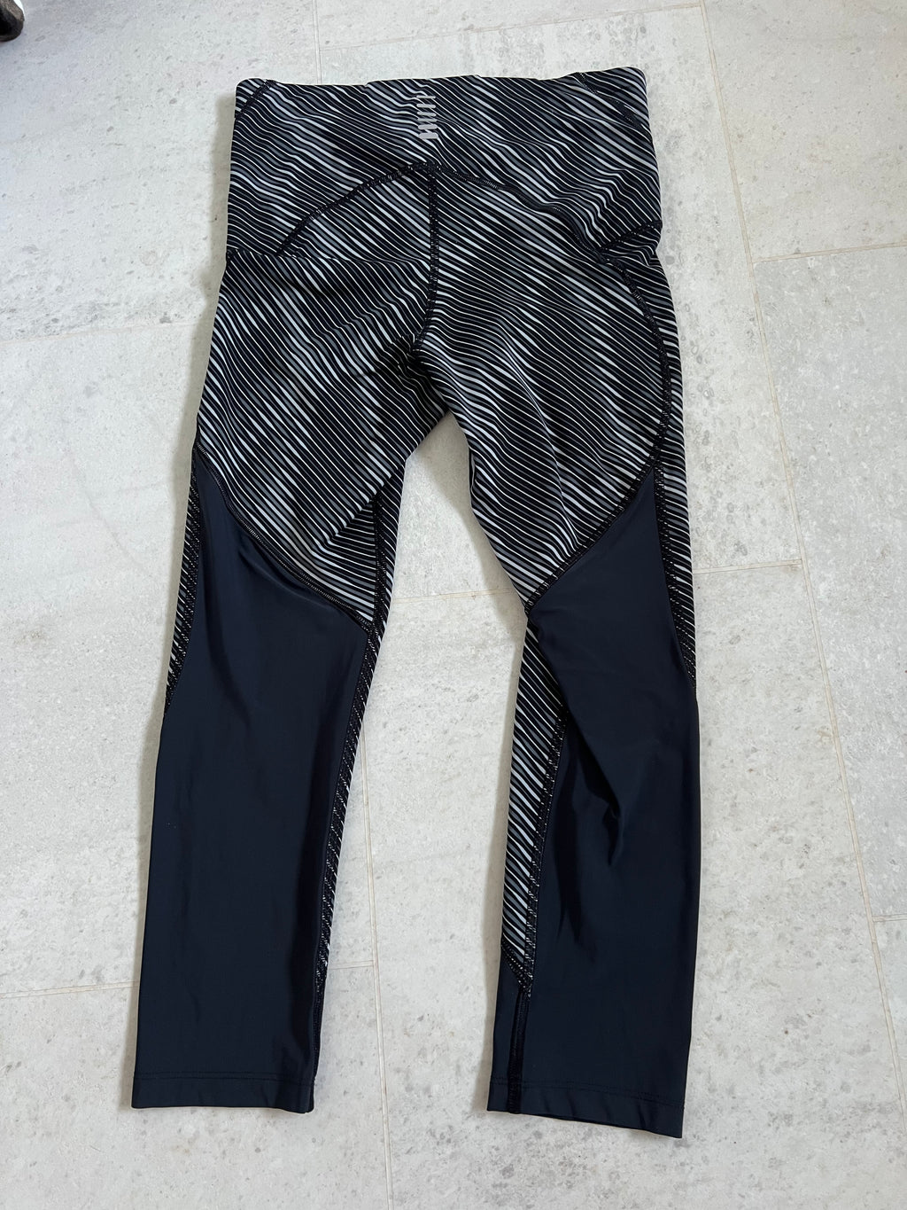 Back view of Under Armour compression cropped leggings highlighting design and panel details