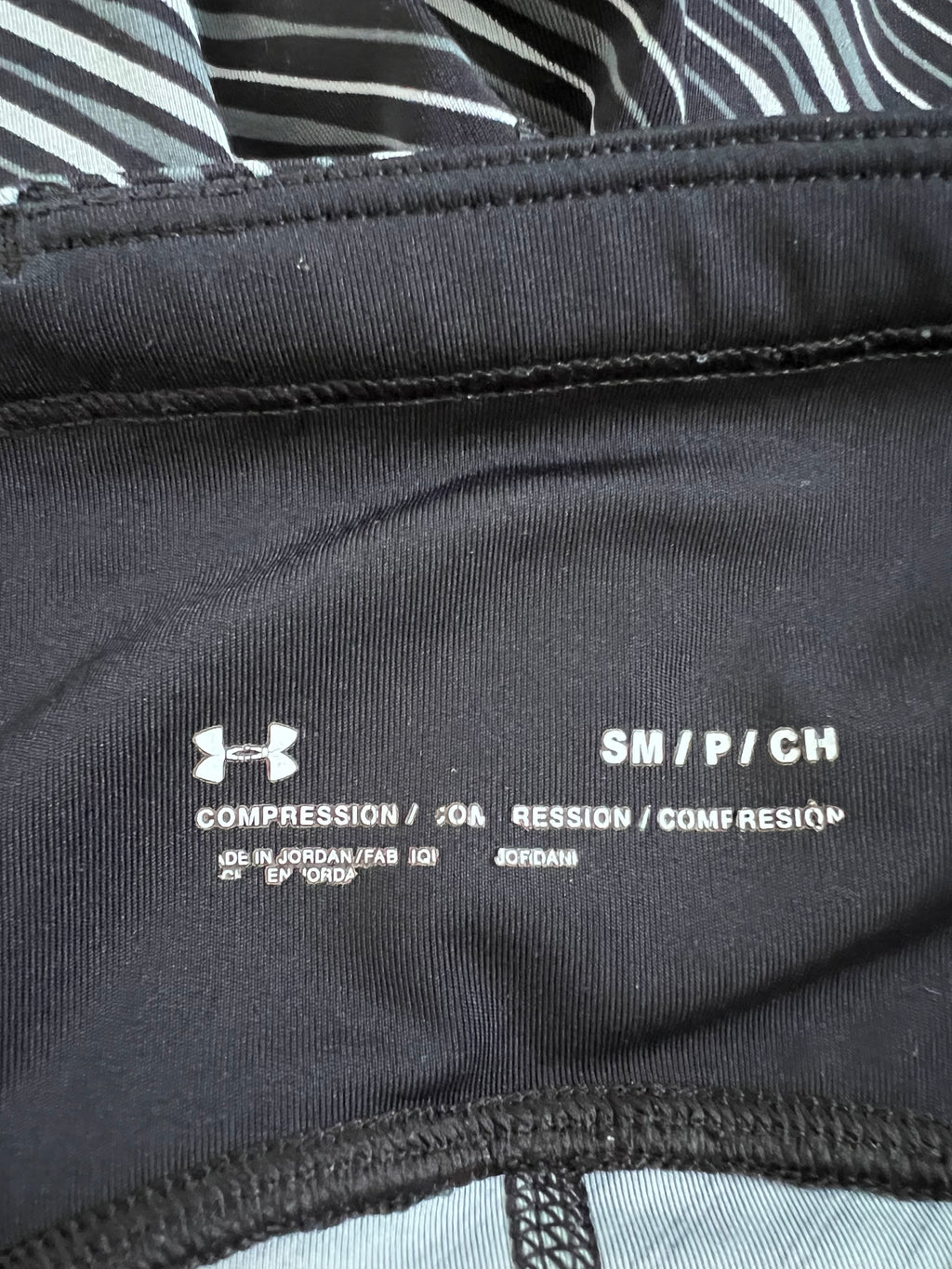 Close-up of inner waistband showing Under Armour logo and size label SM/P/CH