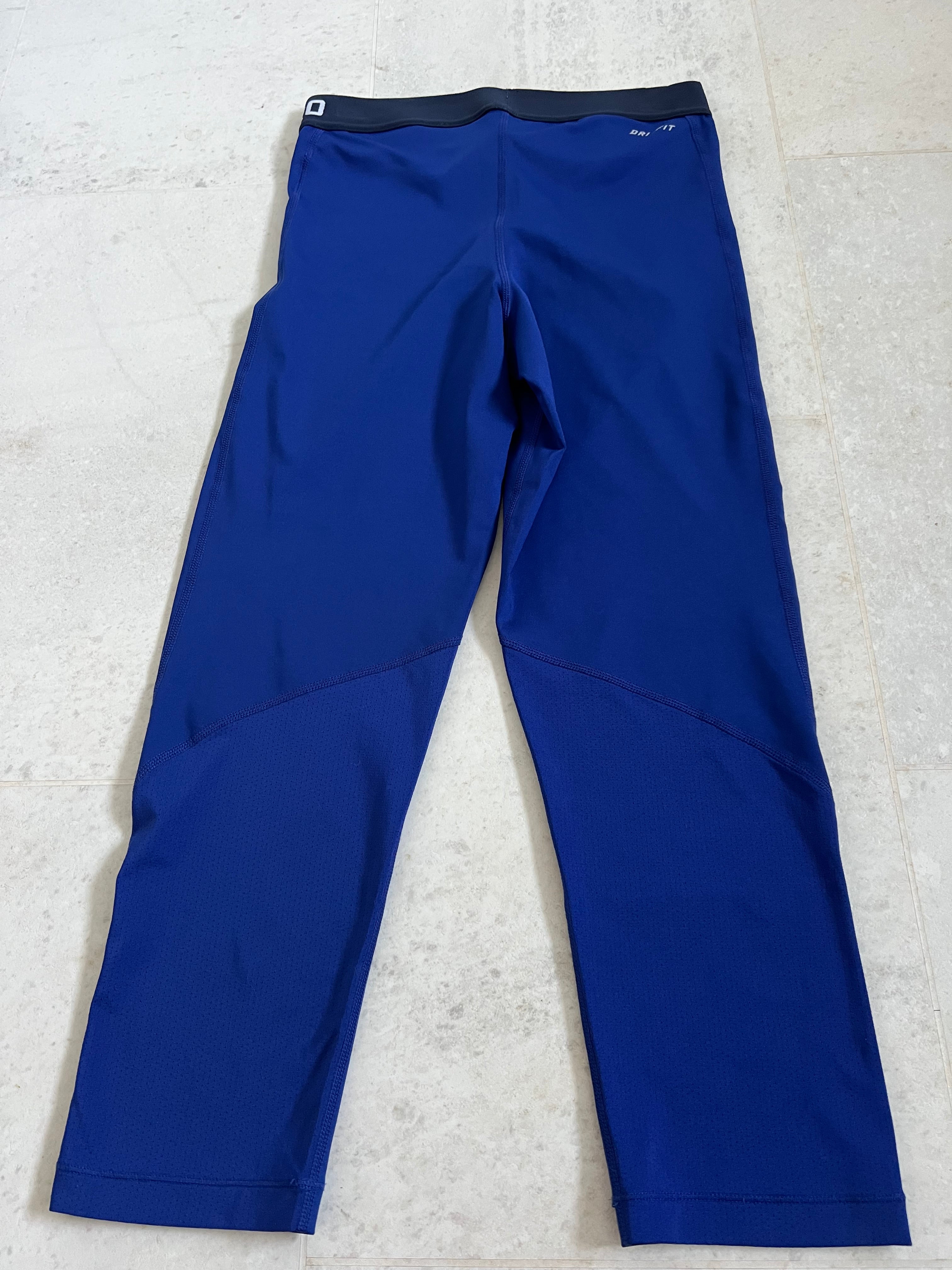 Back view of Nike Pro blue leggings showing mesh panel details on lower legs