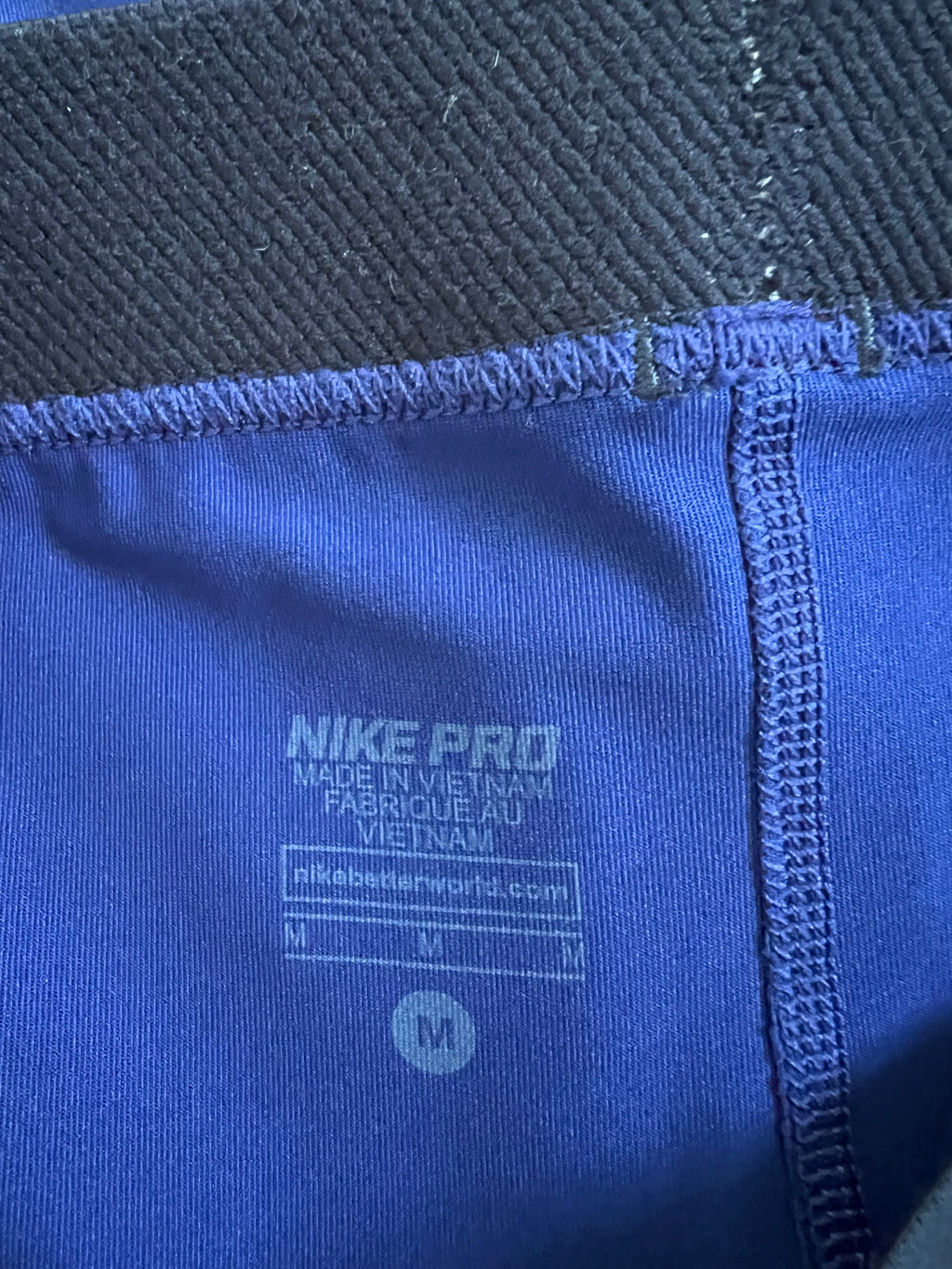 Close-up of internal Nike Pro label showing material and size M