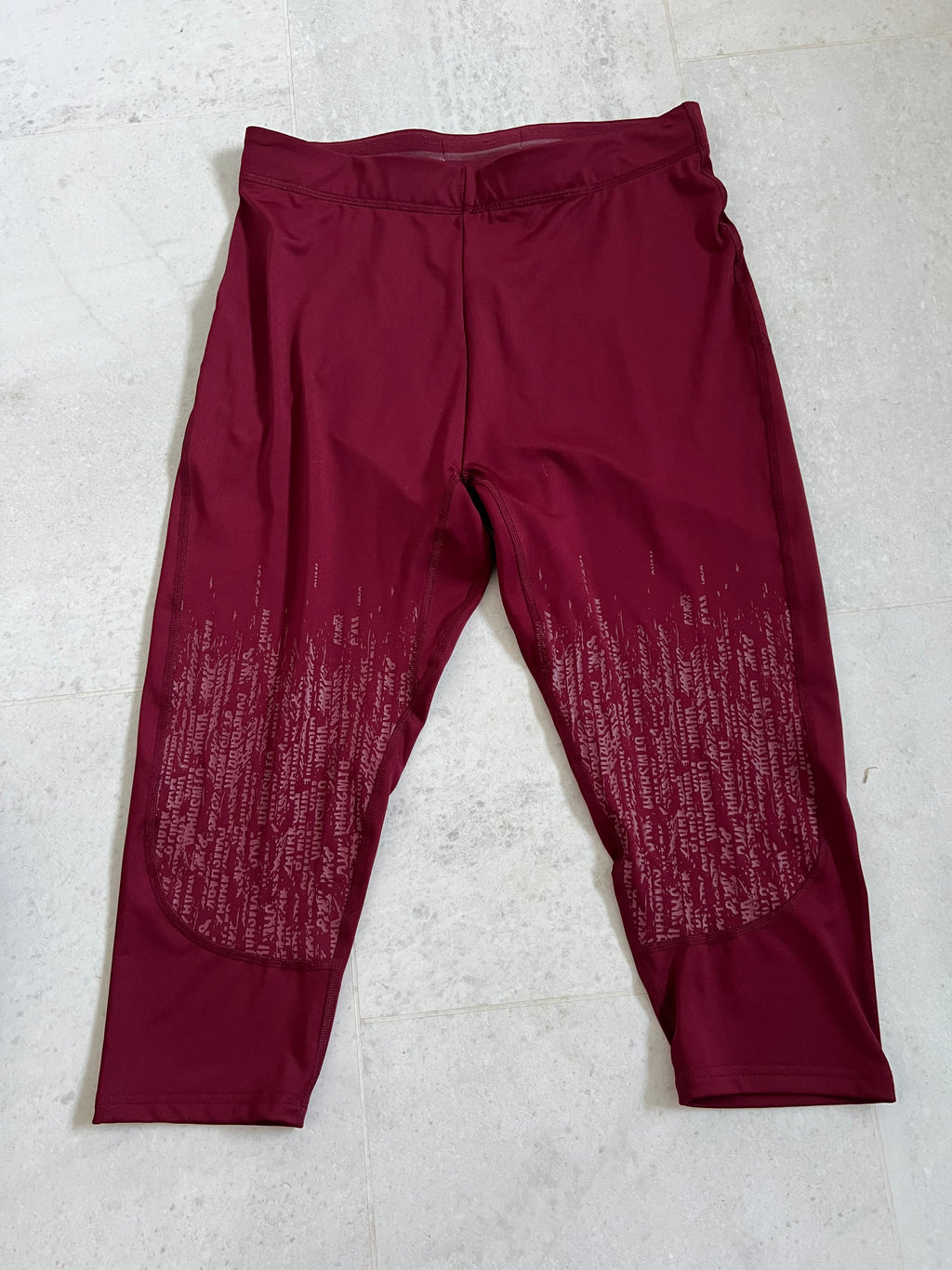 Front view of burgundy Gymshark cropped leggings with patterned detailing on lower legs